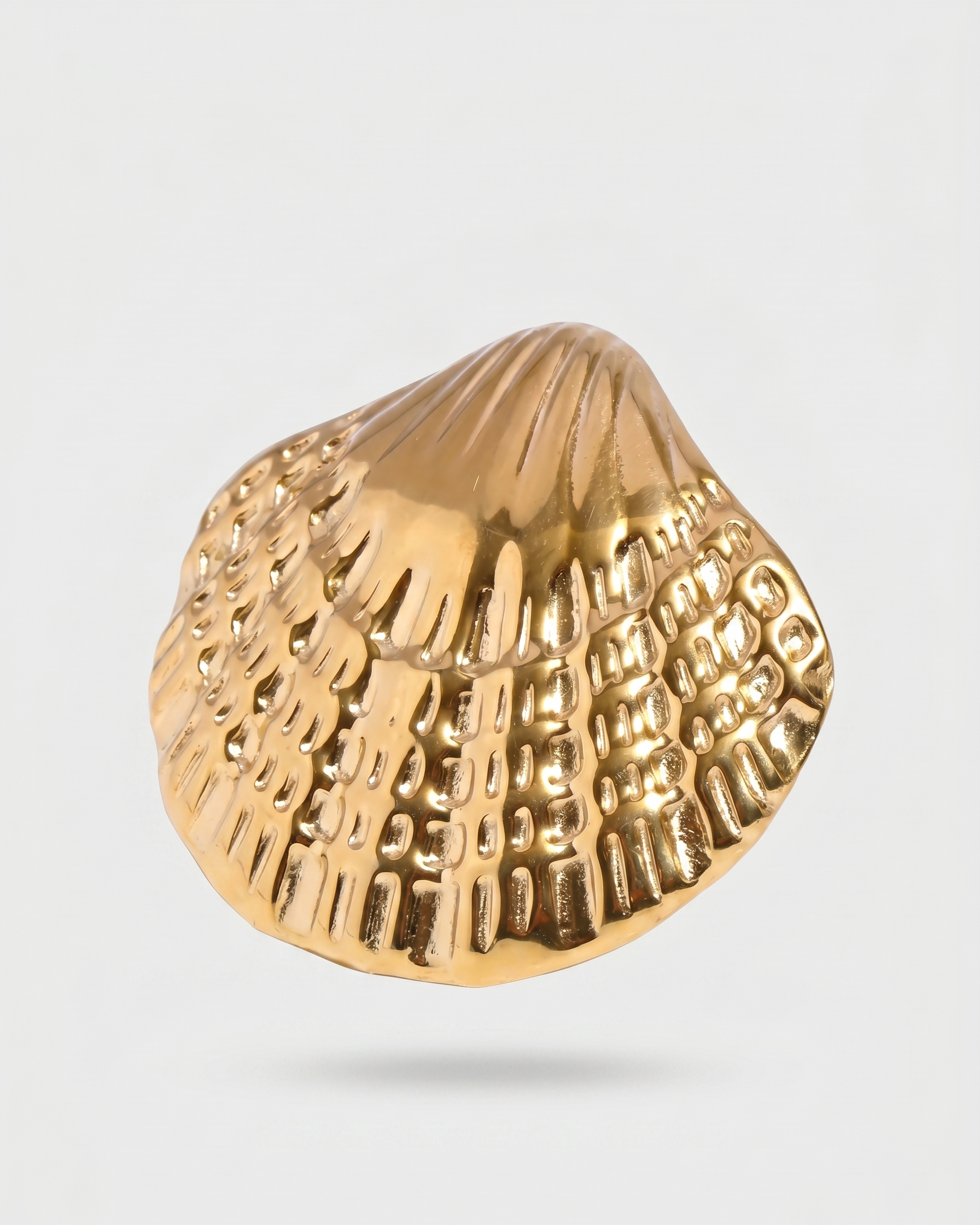 Gold shell-shaped object on a light gray background