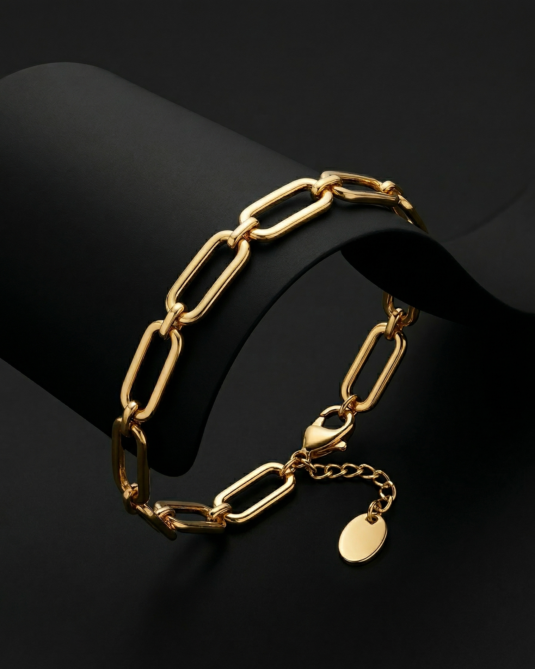 Gold chain bracelet with a tag on a black background