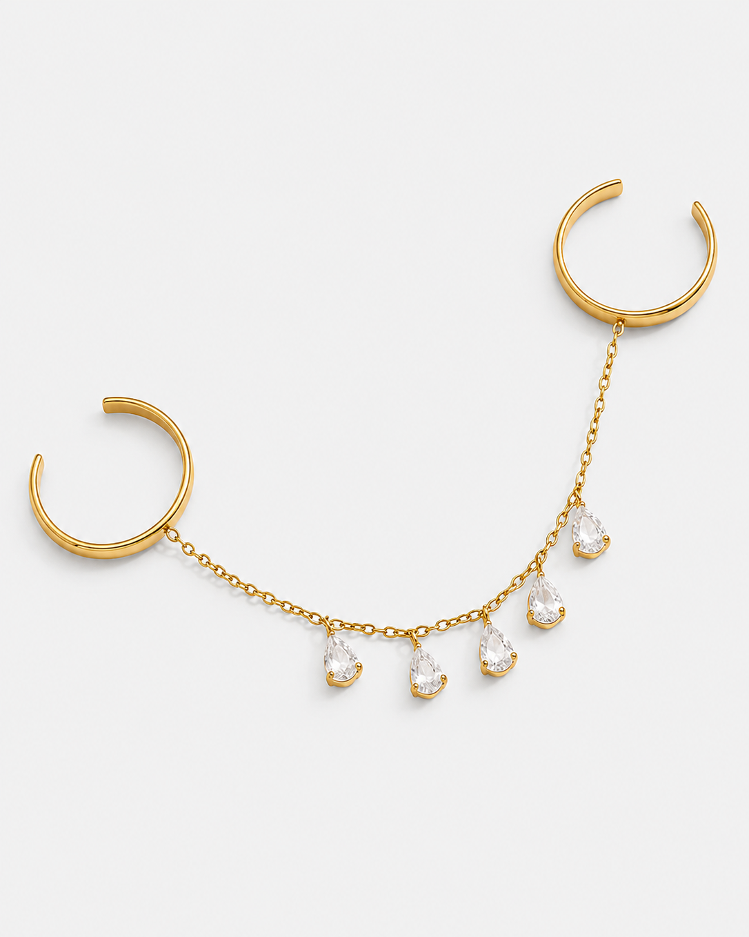 Gold-toned curved chain necklace with two open circular ends and five dangling clear teardrop gemstones, shown on a light gray background.