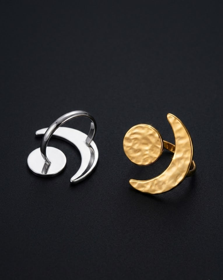 Two rings, one silver and one gold, on a black background