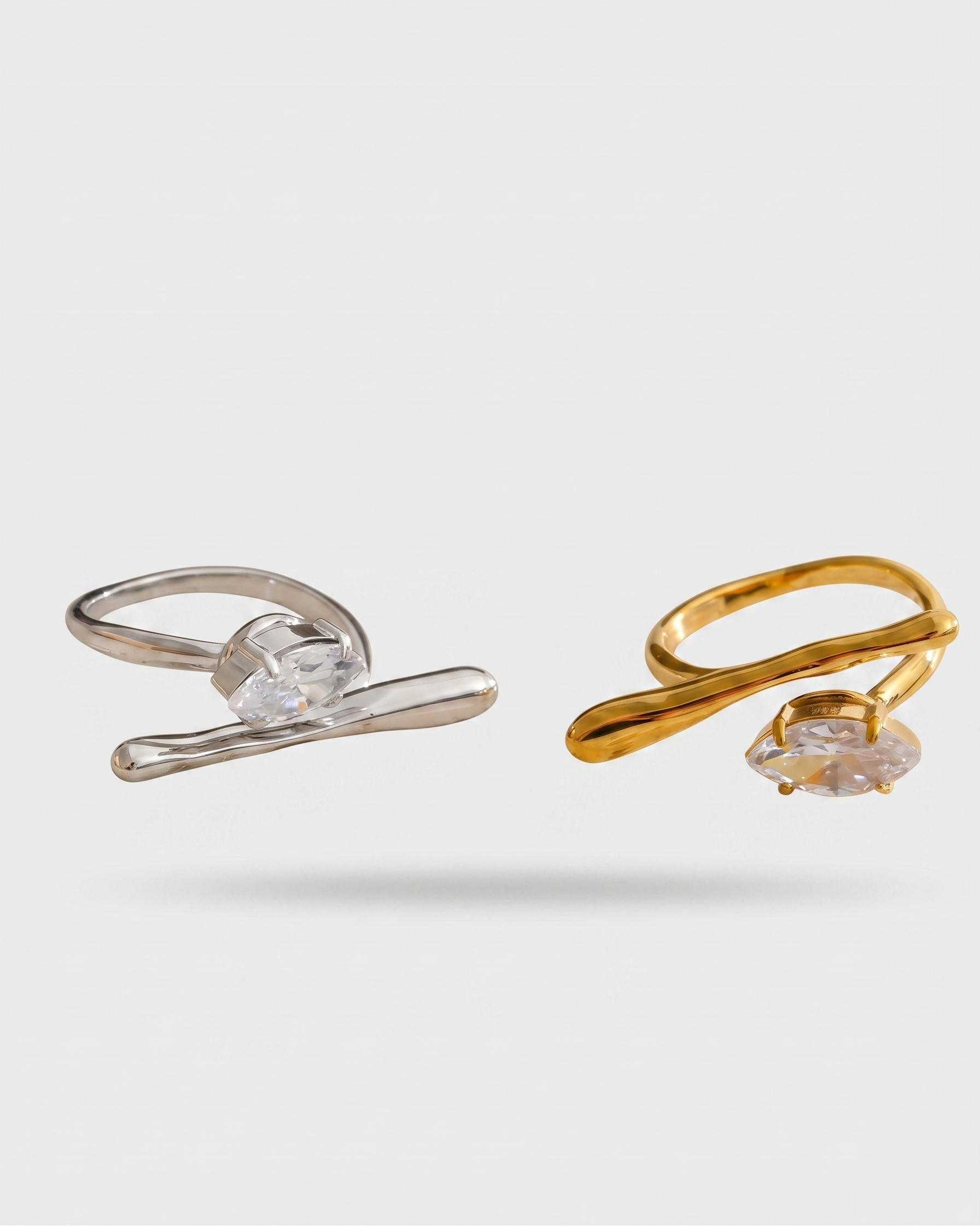 Gold and silver ear cuff with clear gemstones on a light gray background