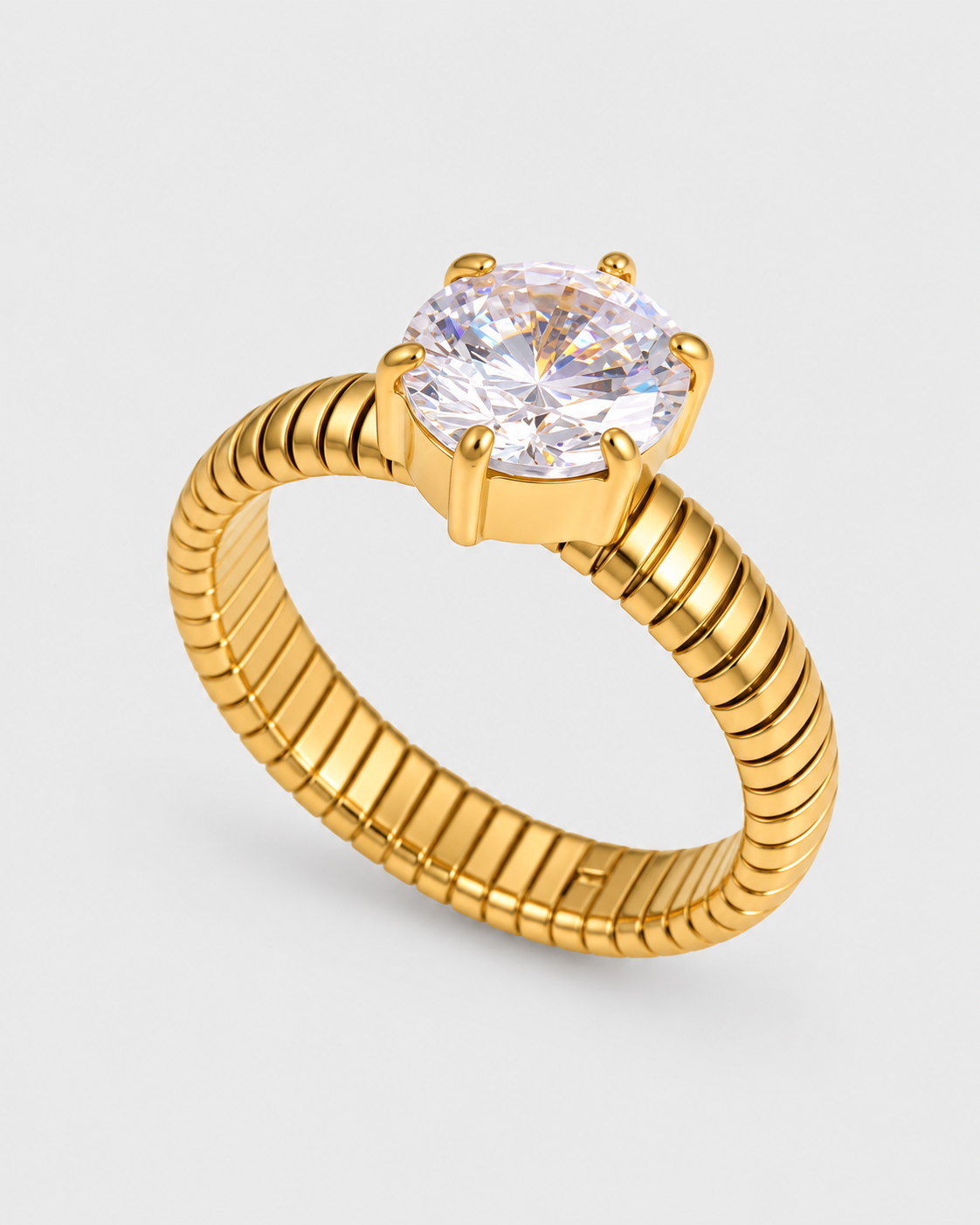 A yellow gold snake-belt-style ring with a large round brilliant-cut clear gemstone in a four-prong setting, shown on a light gray background.