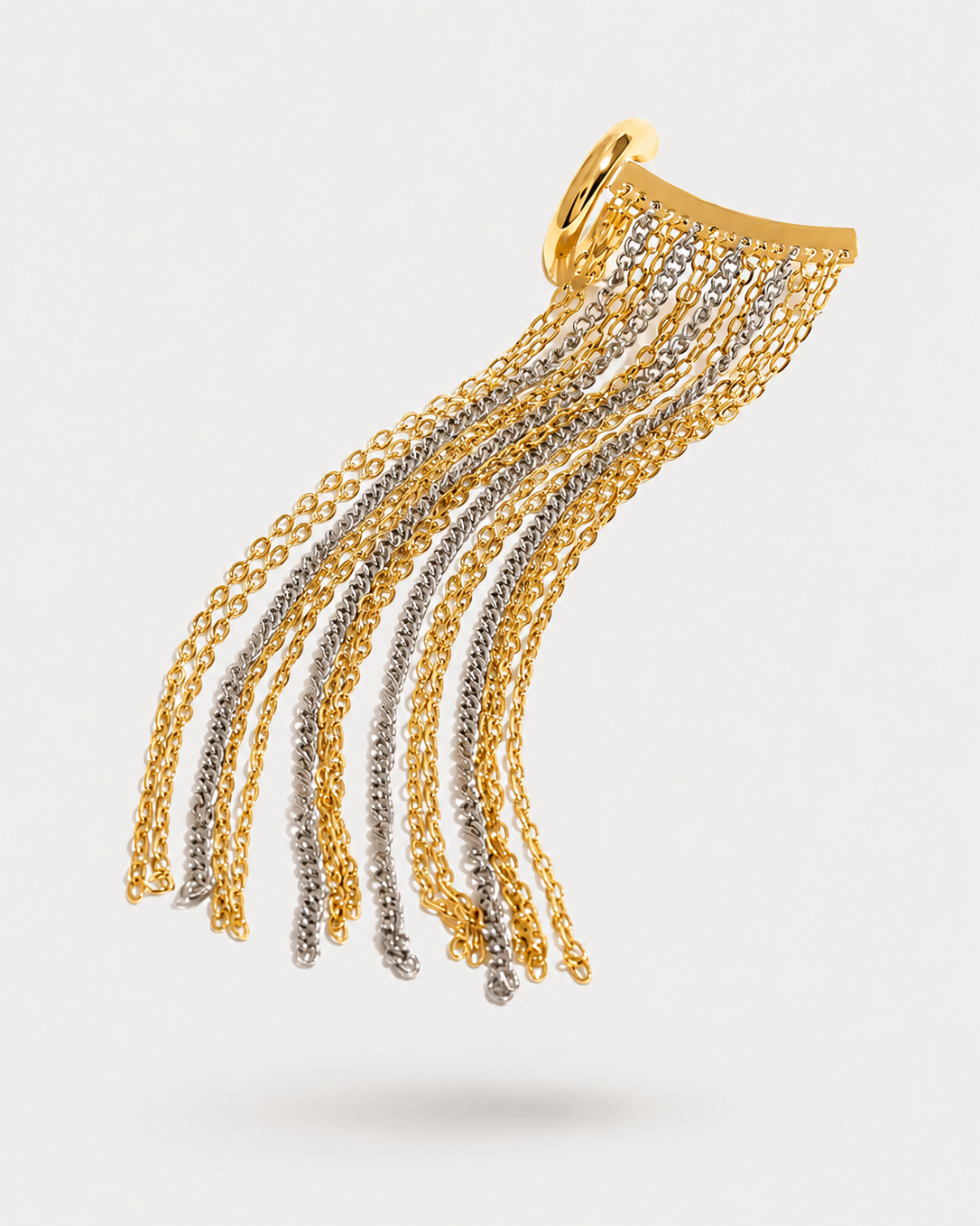 A gold and silver double-strand chain tassel earring with a curved top bar and a small circular ring at the top, shown against a light gray background.
