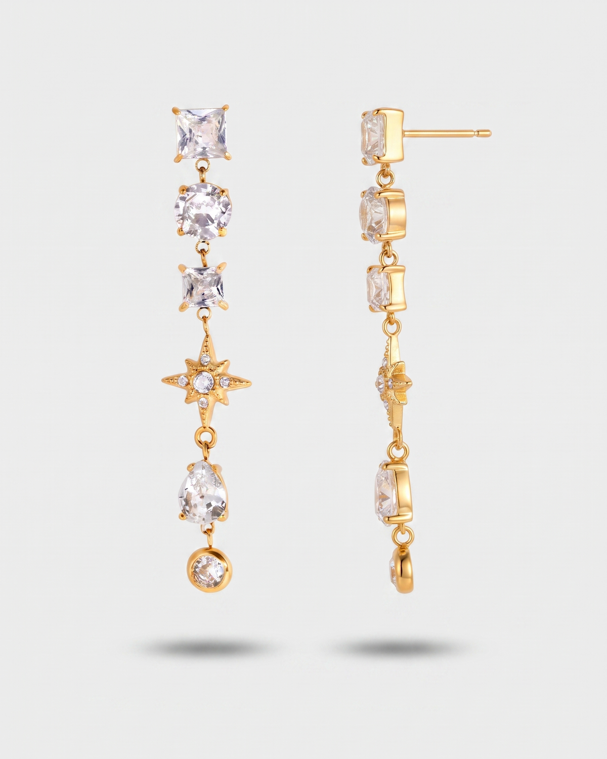 A pair of gold dangle earrings with clear square and teardrop gemstones, shown from both the front and side angles against a light gray background.