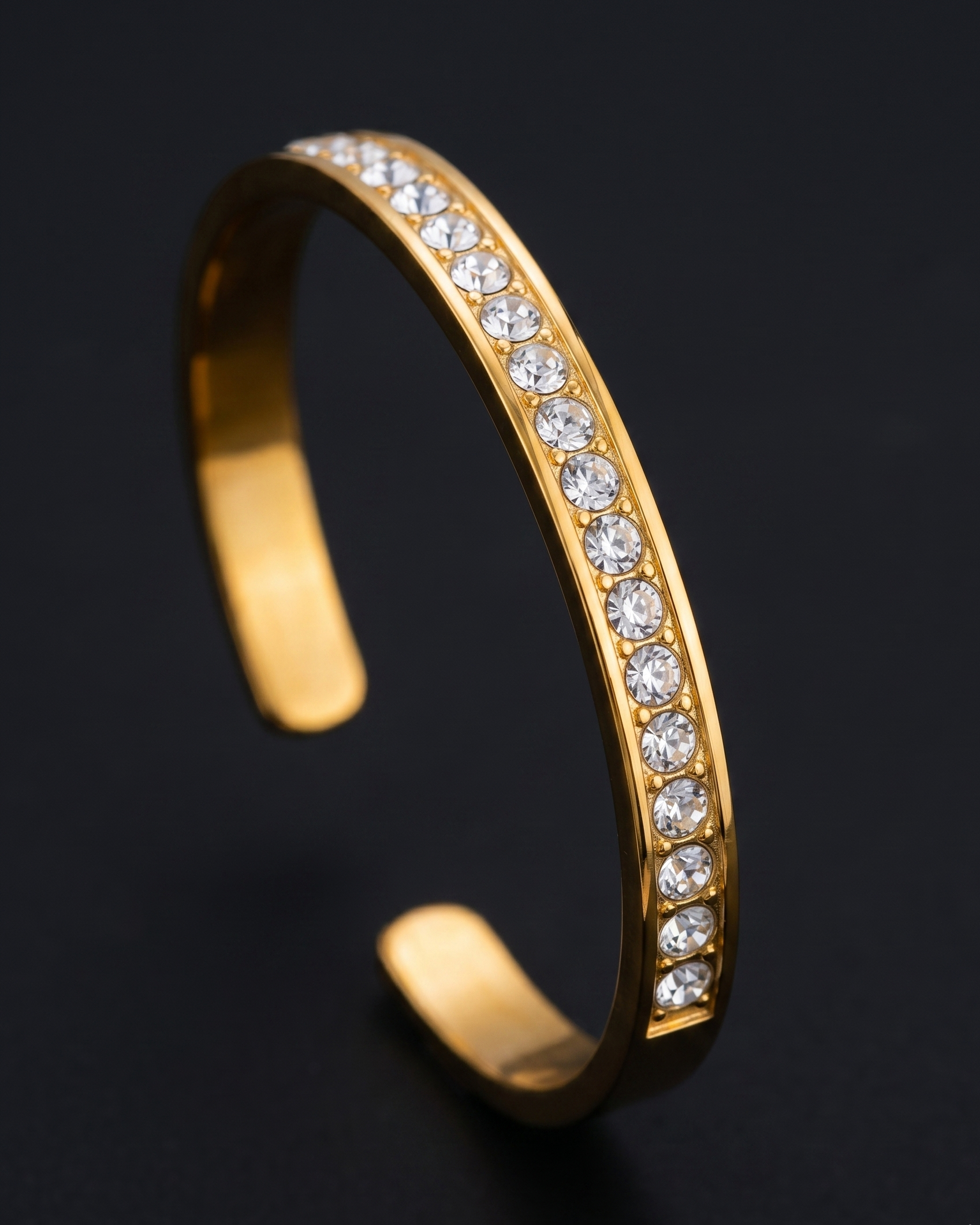 Gold bracelet with embedded diamonds on a black background