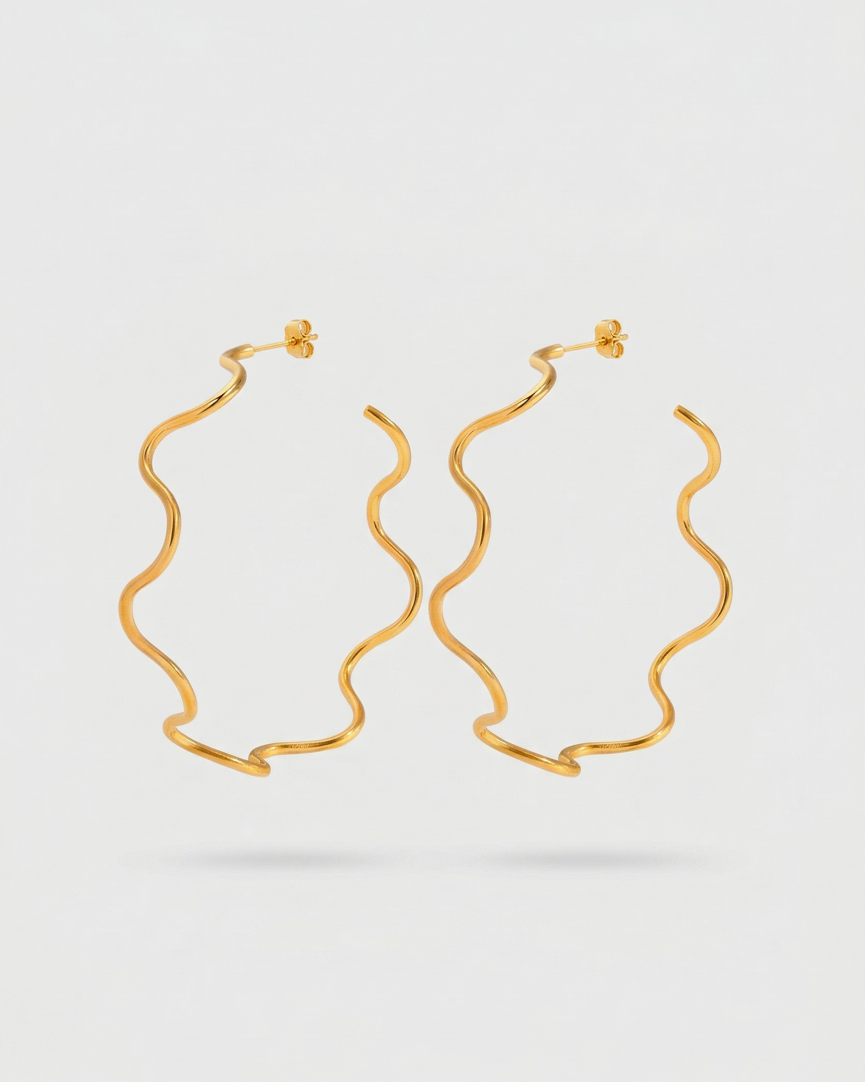 Gold hoop earrings on a light gray background