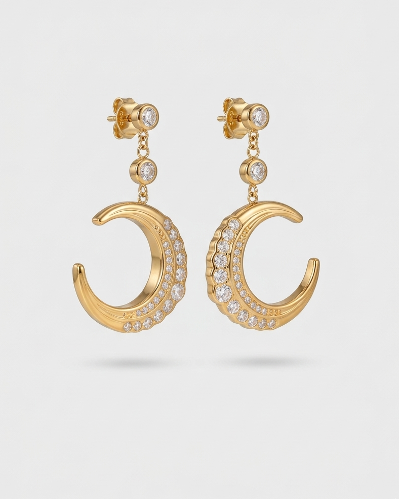 Gold crescent moon earrings with diamond accents on a light gray background