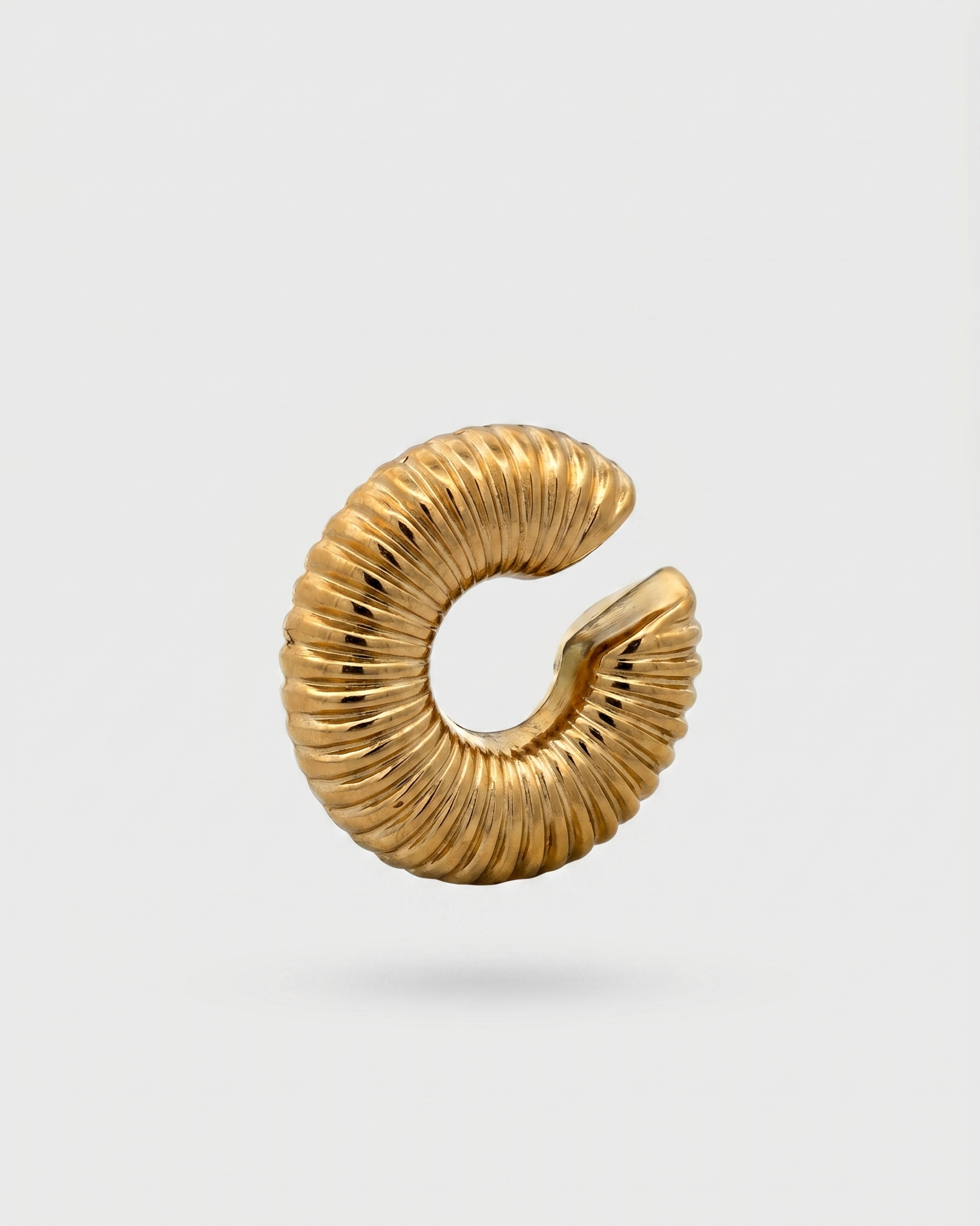 Gold spiral earring on a light gray background