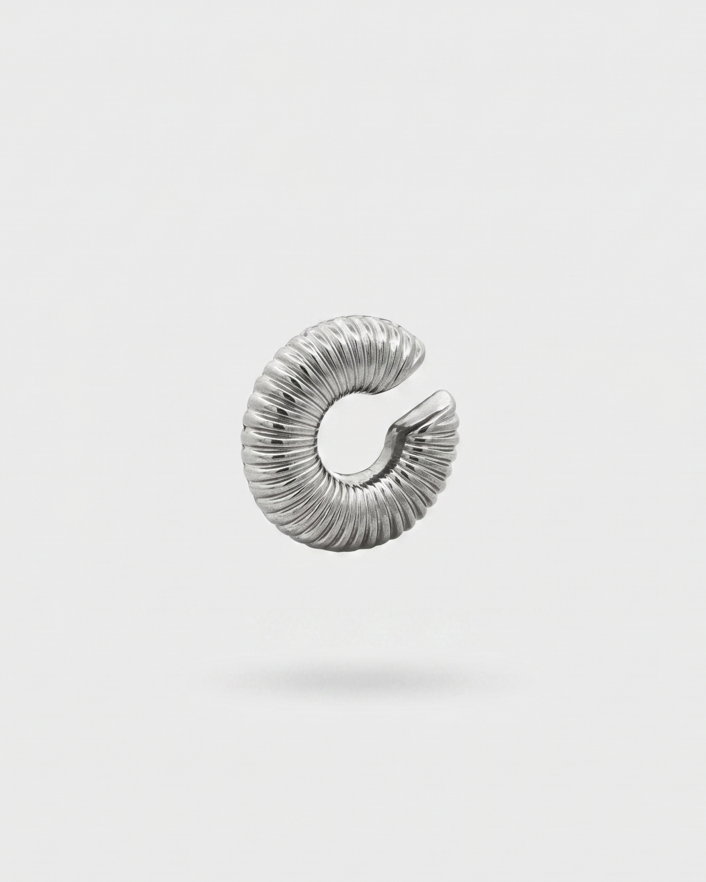 Silver spiral earring on a light gray background