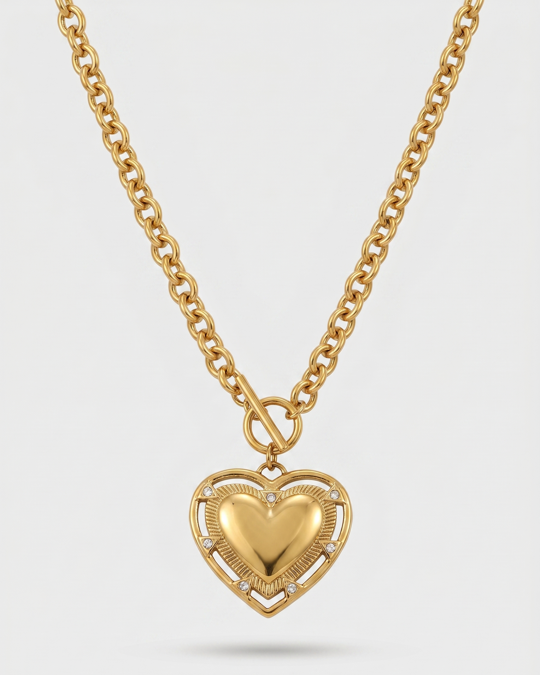 Gold heart-shaped pendant necklace on a light gray background