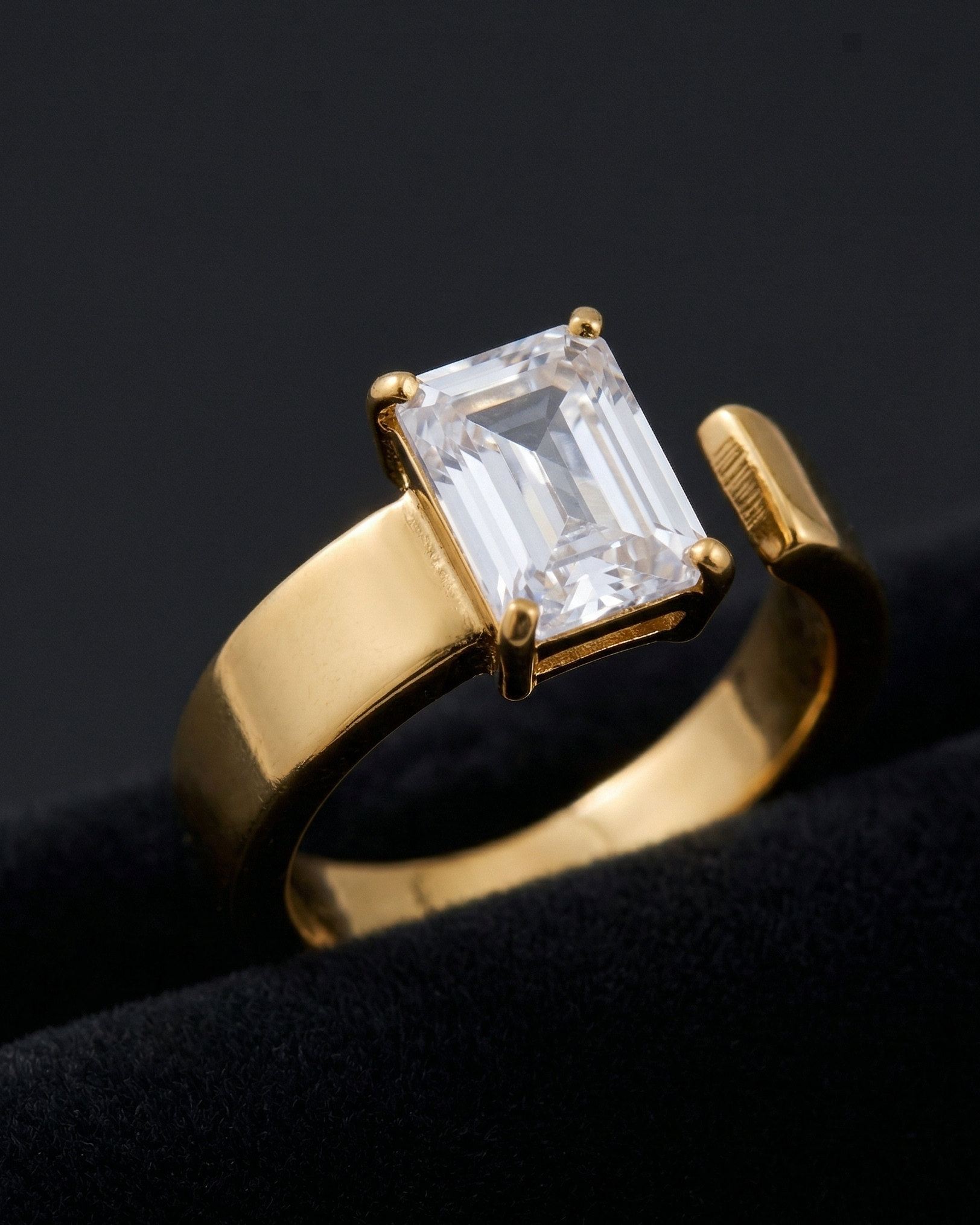 Gold ring with a large rectangular diamond on a black background