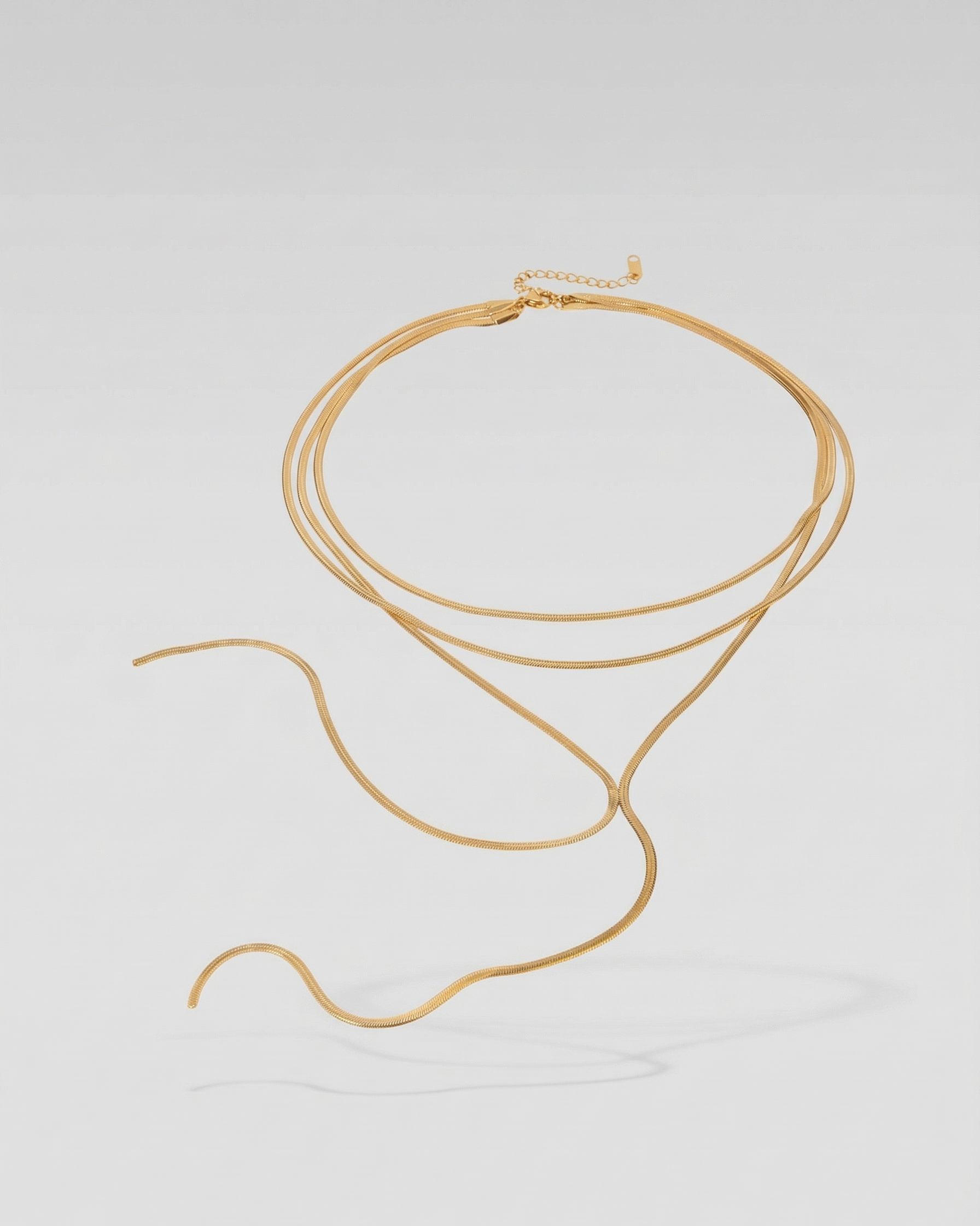 Gold necklace on a light gray background