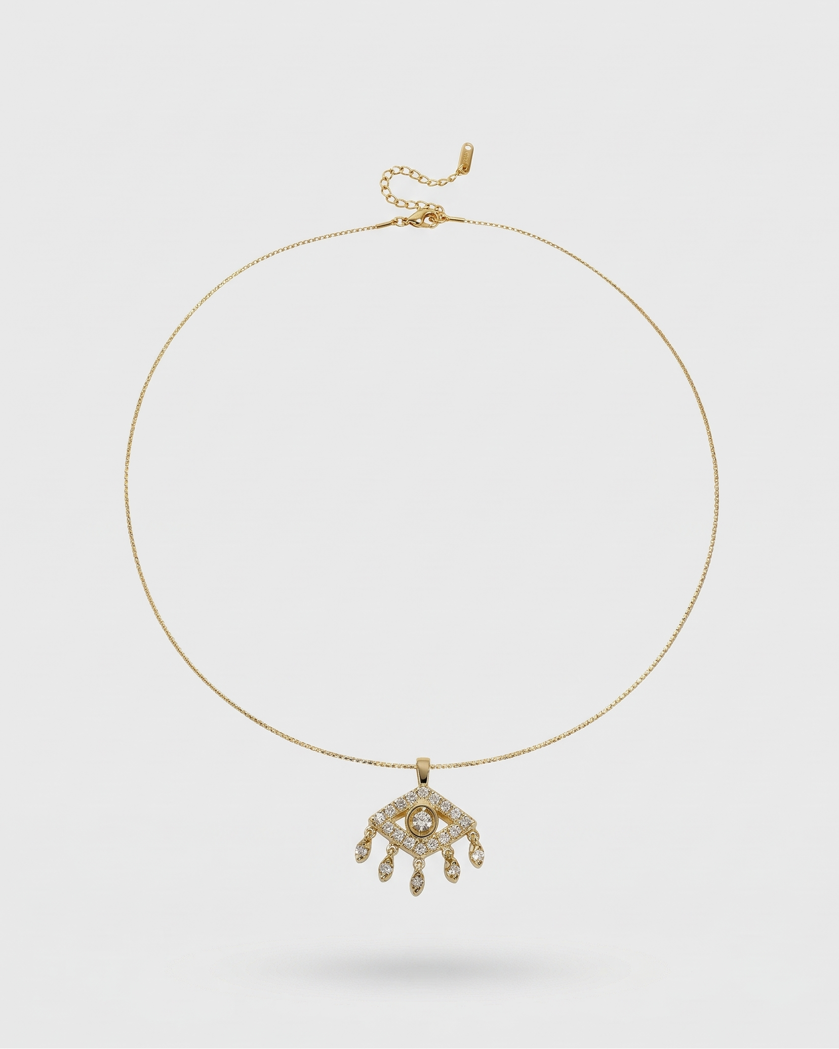 Gold necklace with a pendant on a light gray background