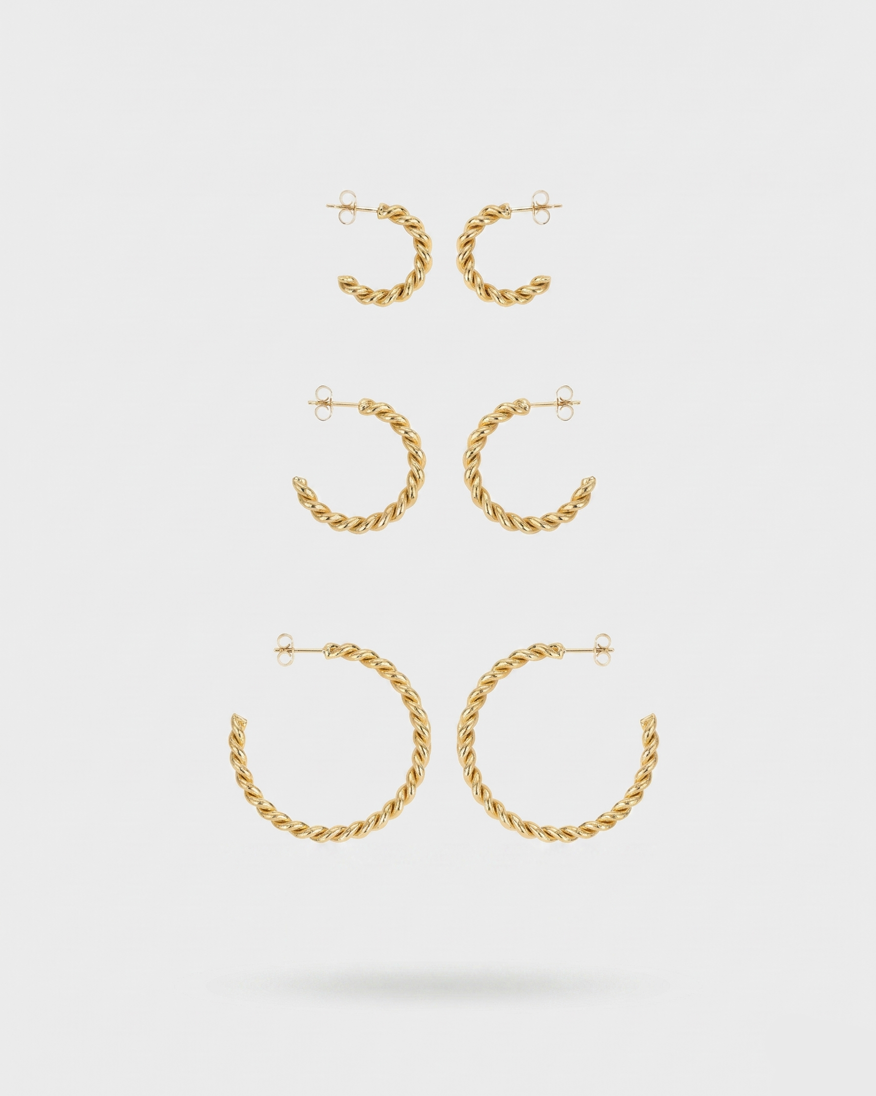 Set of gold hoop earrings on a white background