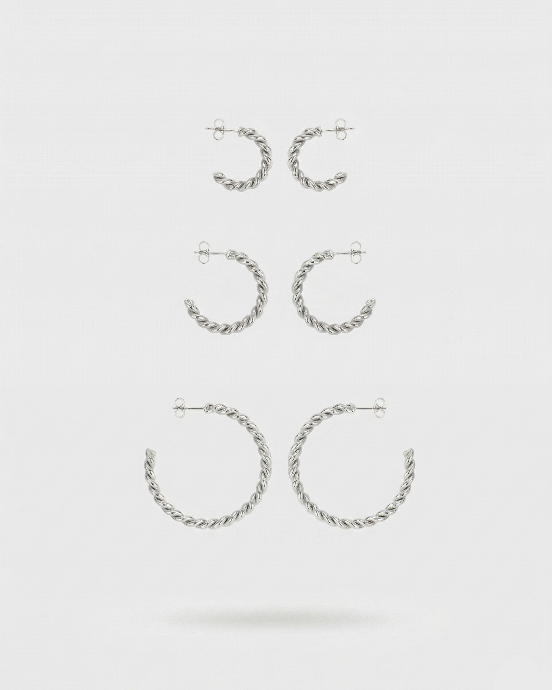 Set of silver hoop earrings on a white background