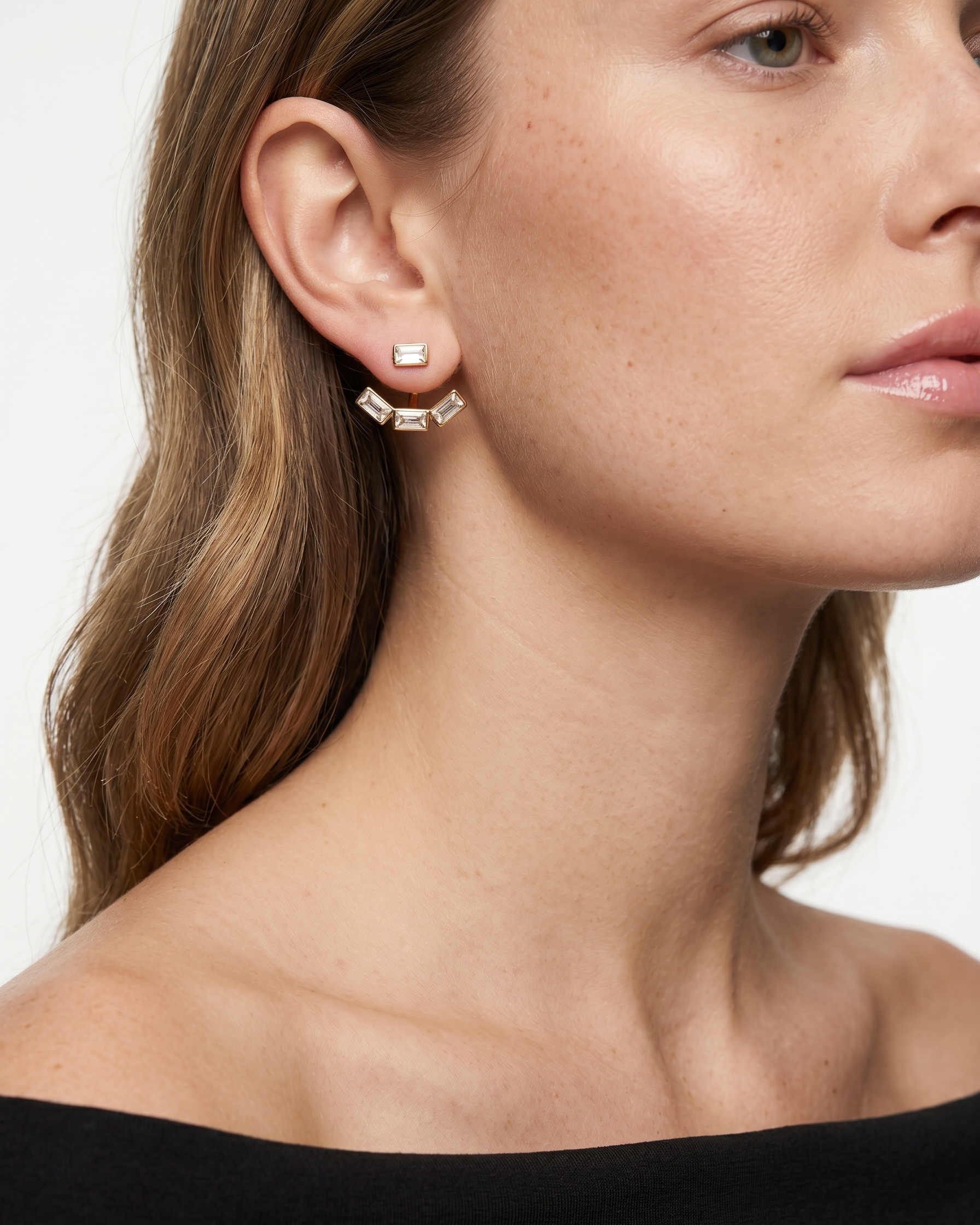 Close-up of a woman wearing geometric earrings with a neutral background