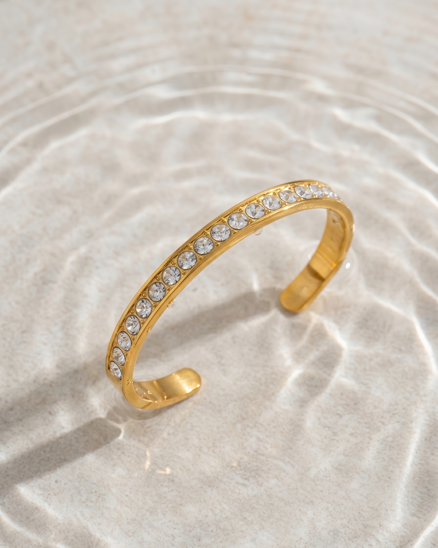 Gold bracelet with crystals on a light background