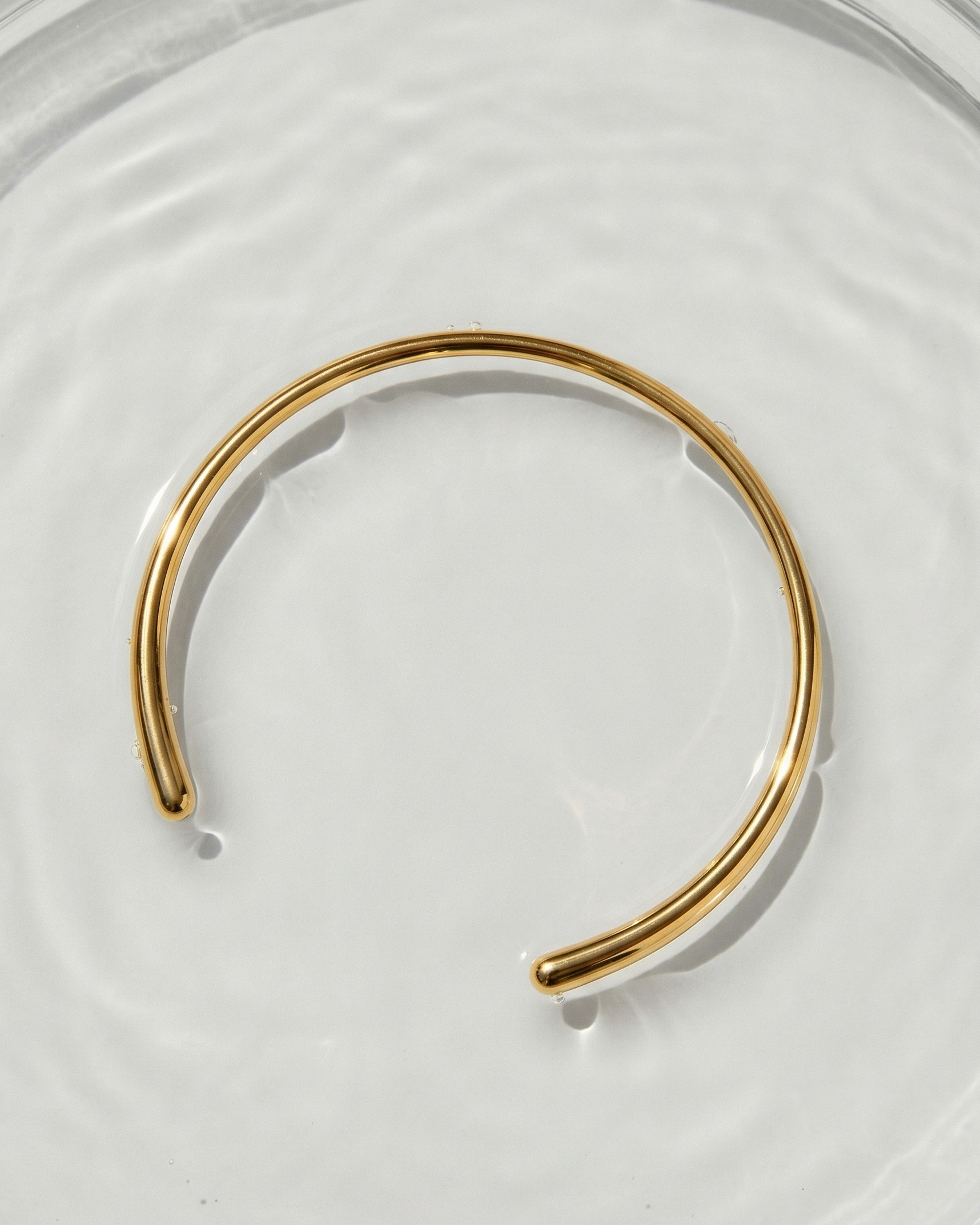 Gold bracelet on a white plate