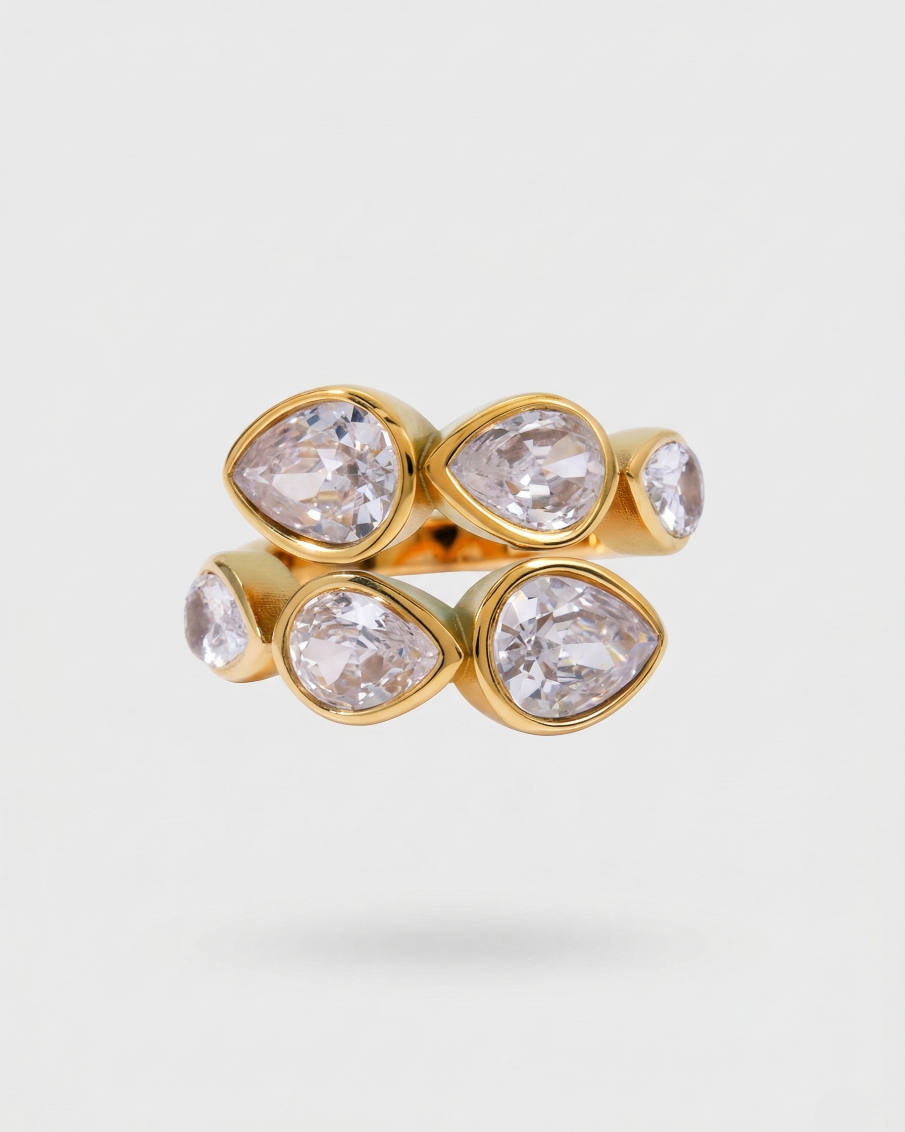 Gold ring with teardrop-shaped crystals on a light gray background