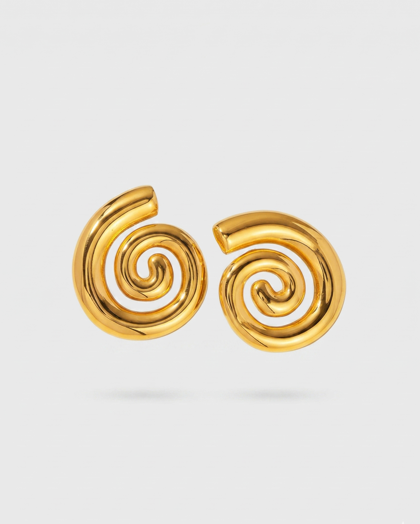 Pair of gold spiral earrings on a light gray background