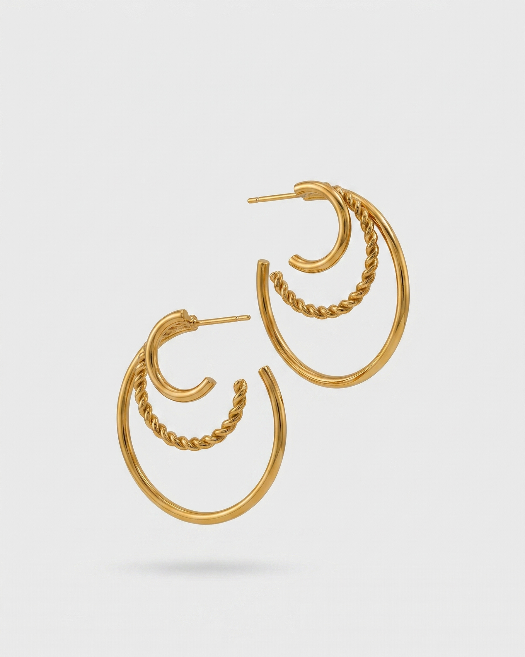 Gold hoop earrings on a light gray background