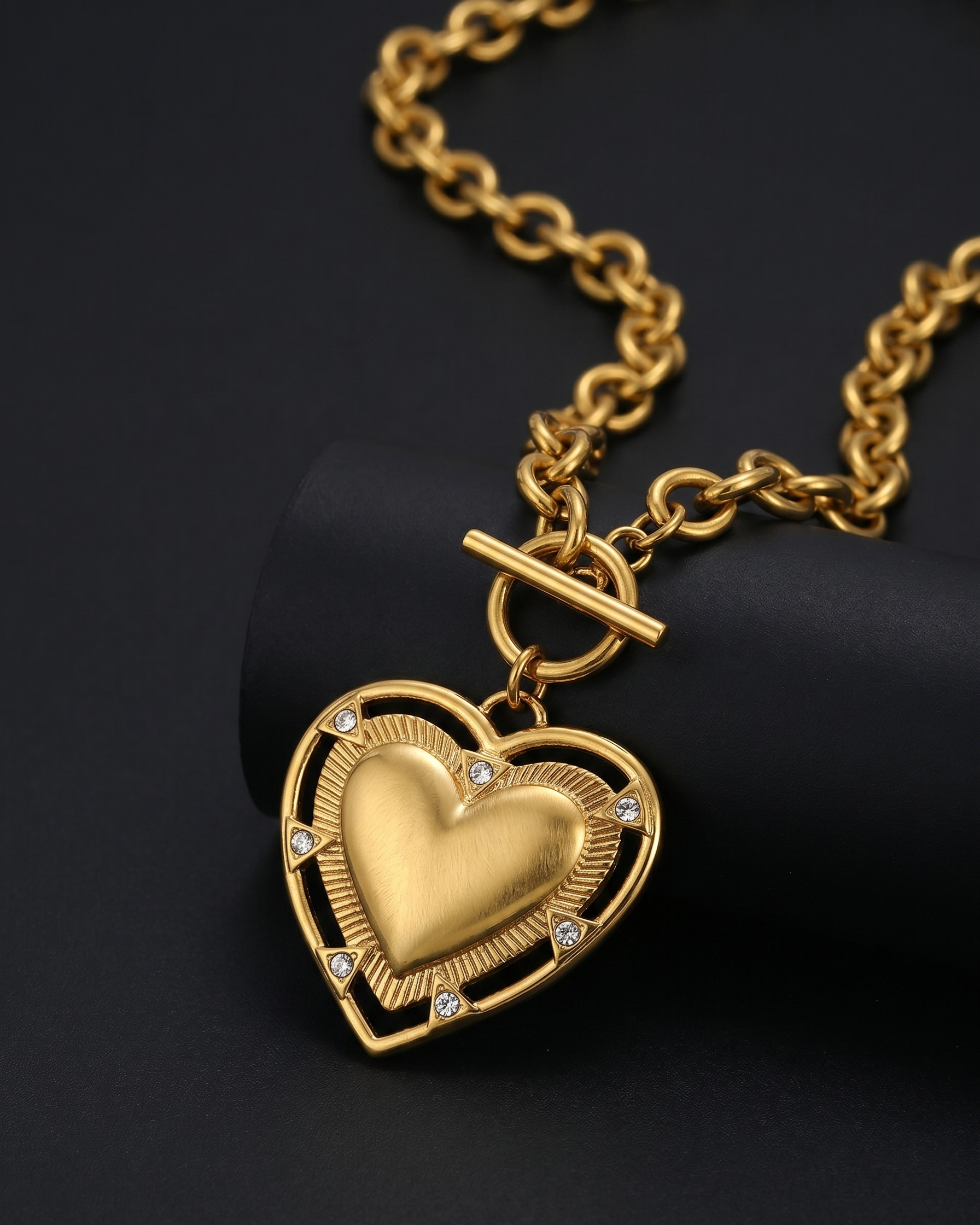Gold heart-shaped pendant necklace on a black background