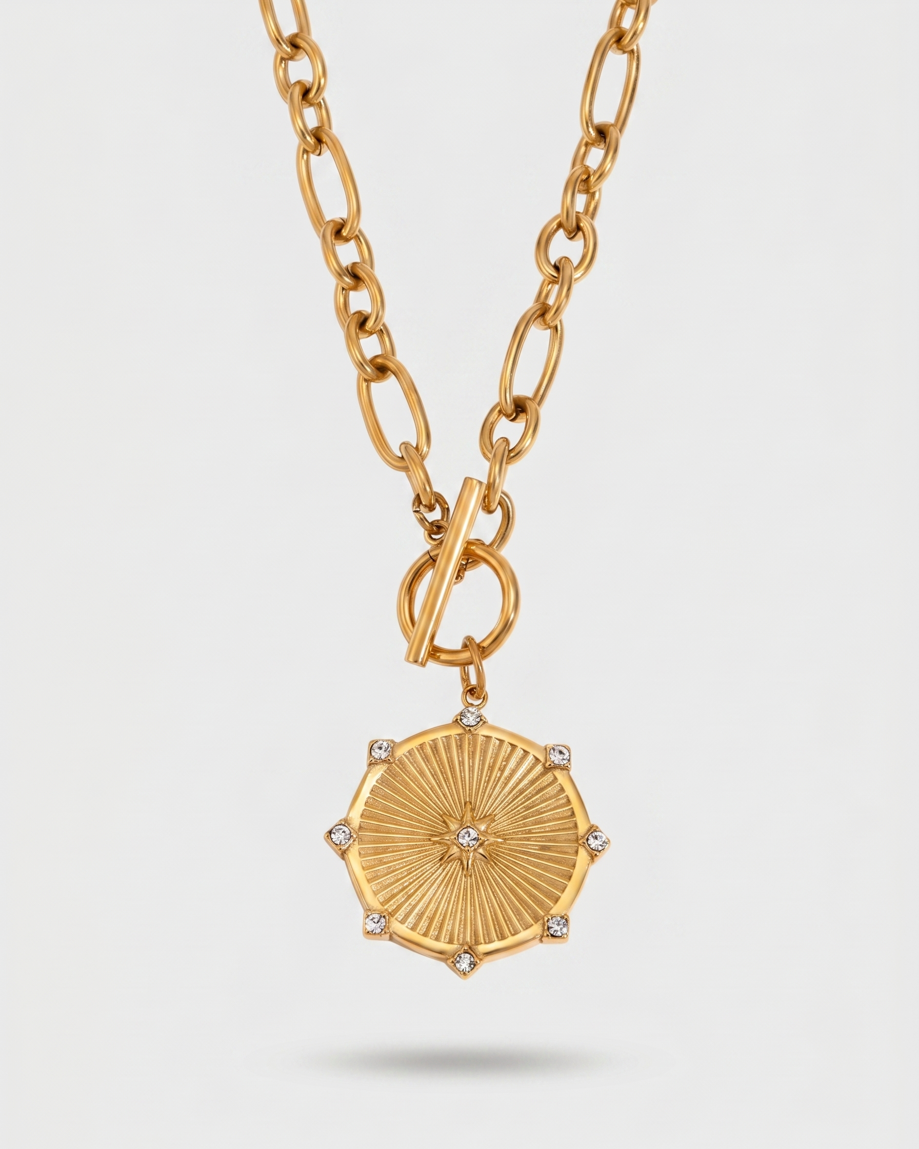 Gold necklace with a decorative pendant on a light gray background