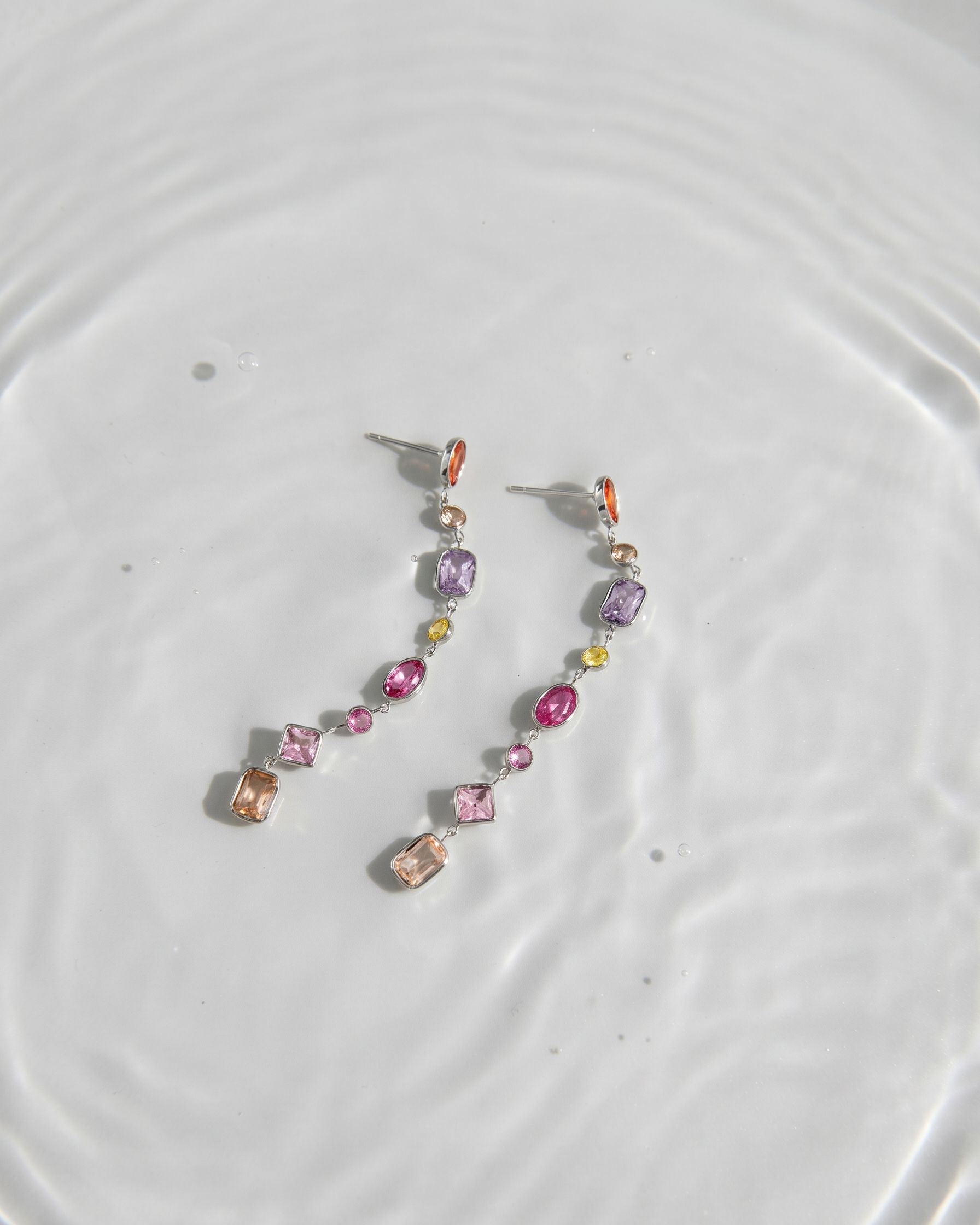 Multicolored beaded earrings on a light gray surface