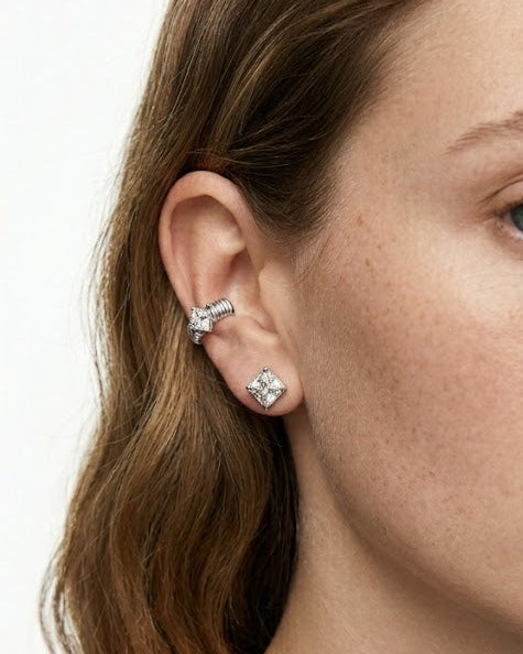 Close-up of a woman wearing diamond earrings on a white background
