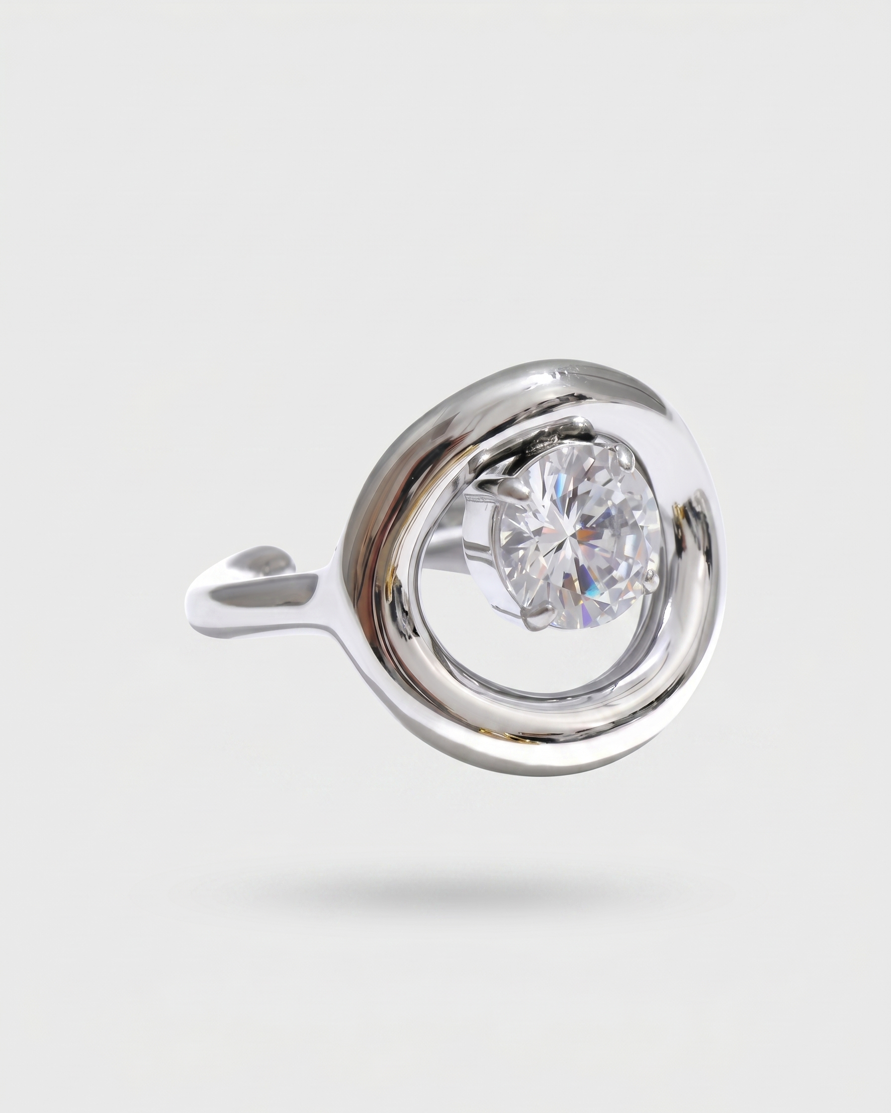 Silver earring with a clear gemstone on a light gray background