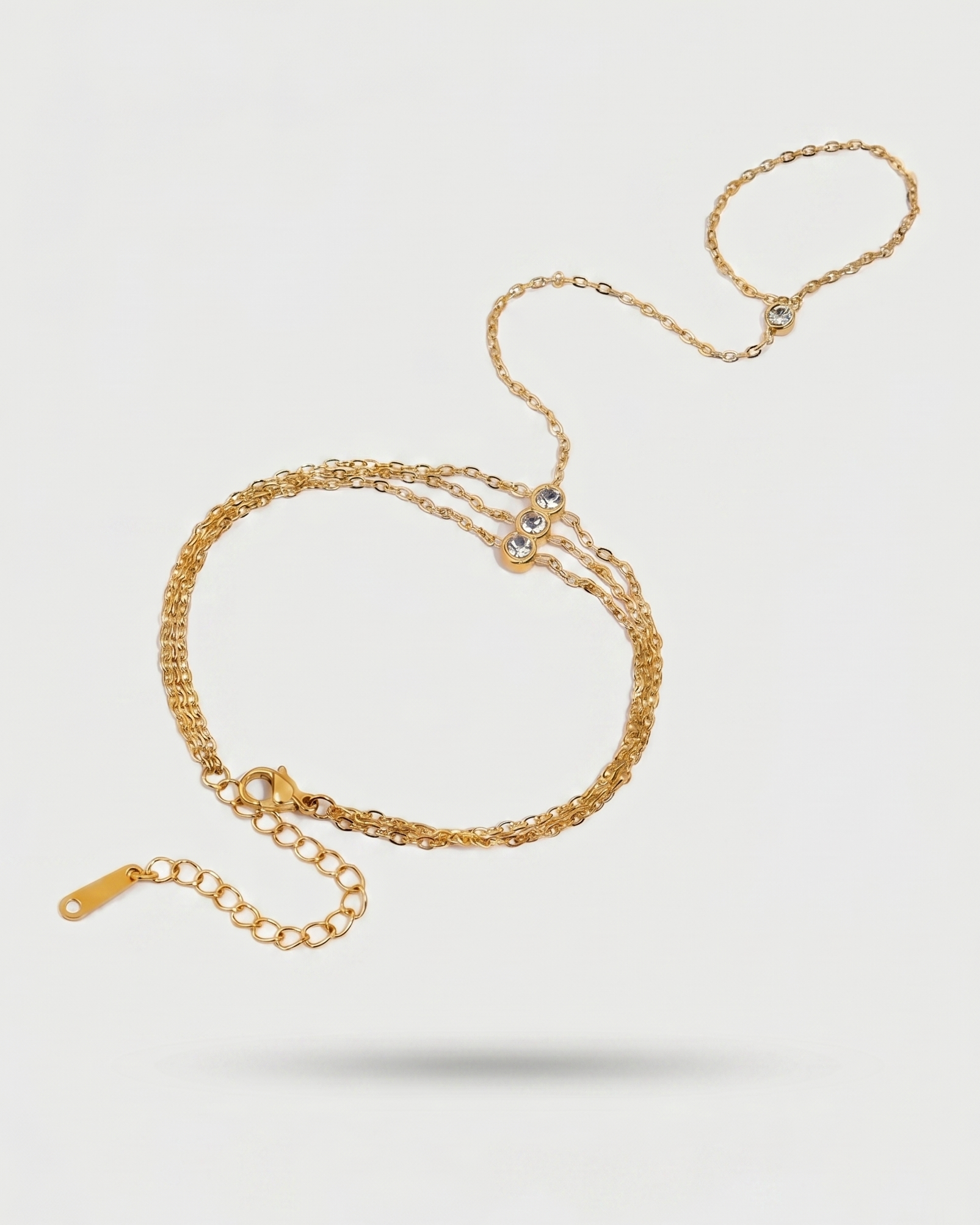 Gold chain bracelet on a light gray background