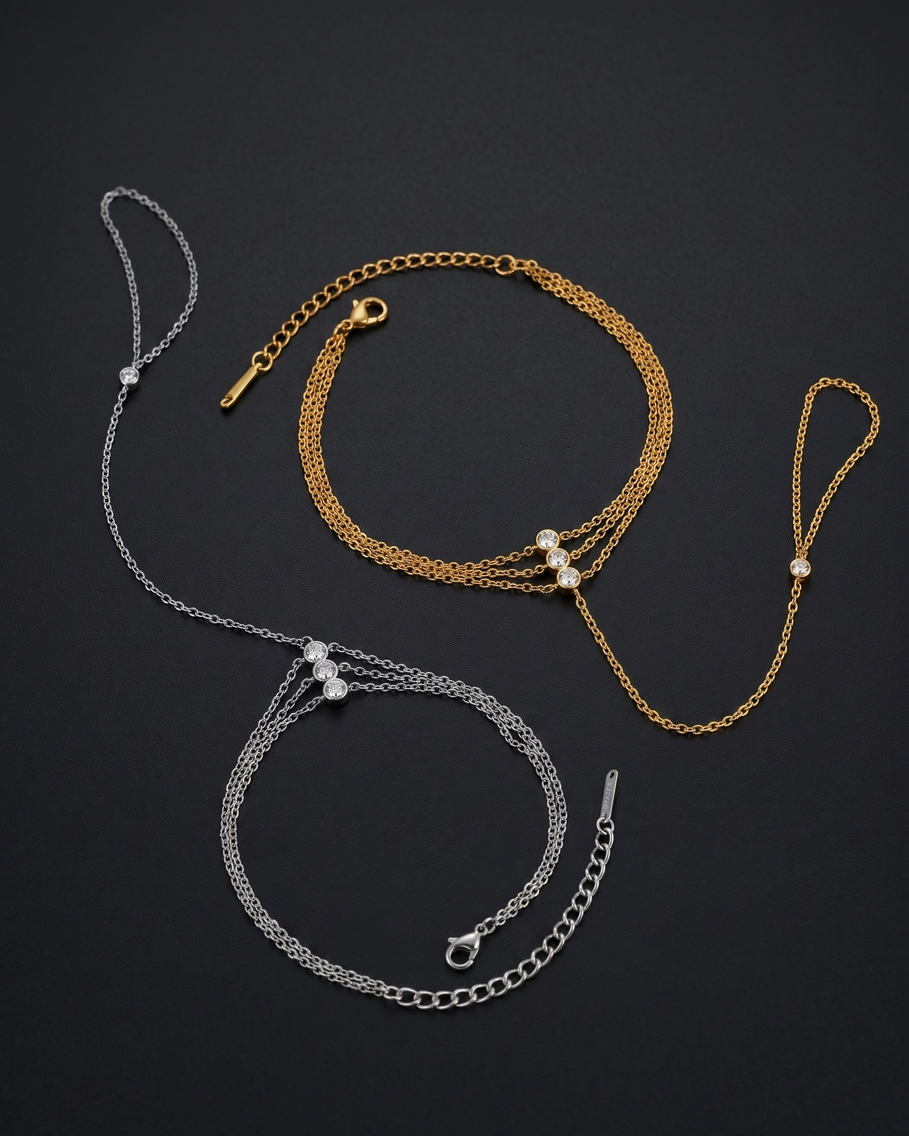 Two gold and one silver bracelet with pearl accents on a black background