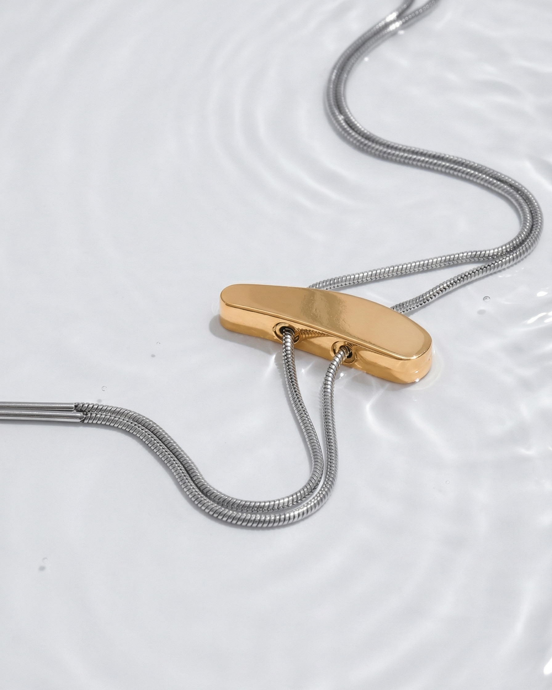 Gold clip on a silver cord against a white background