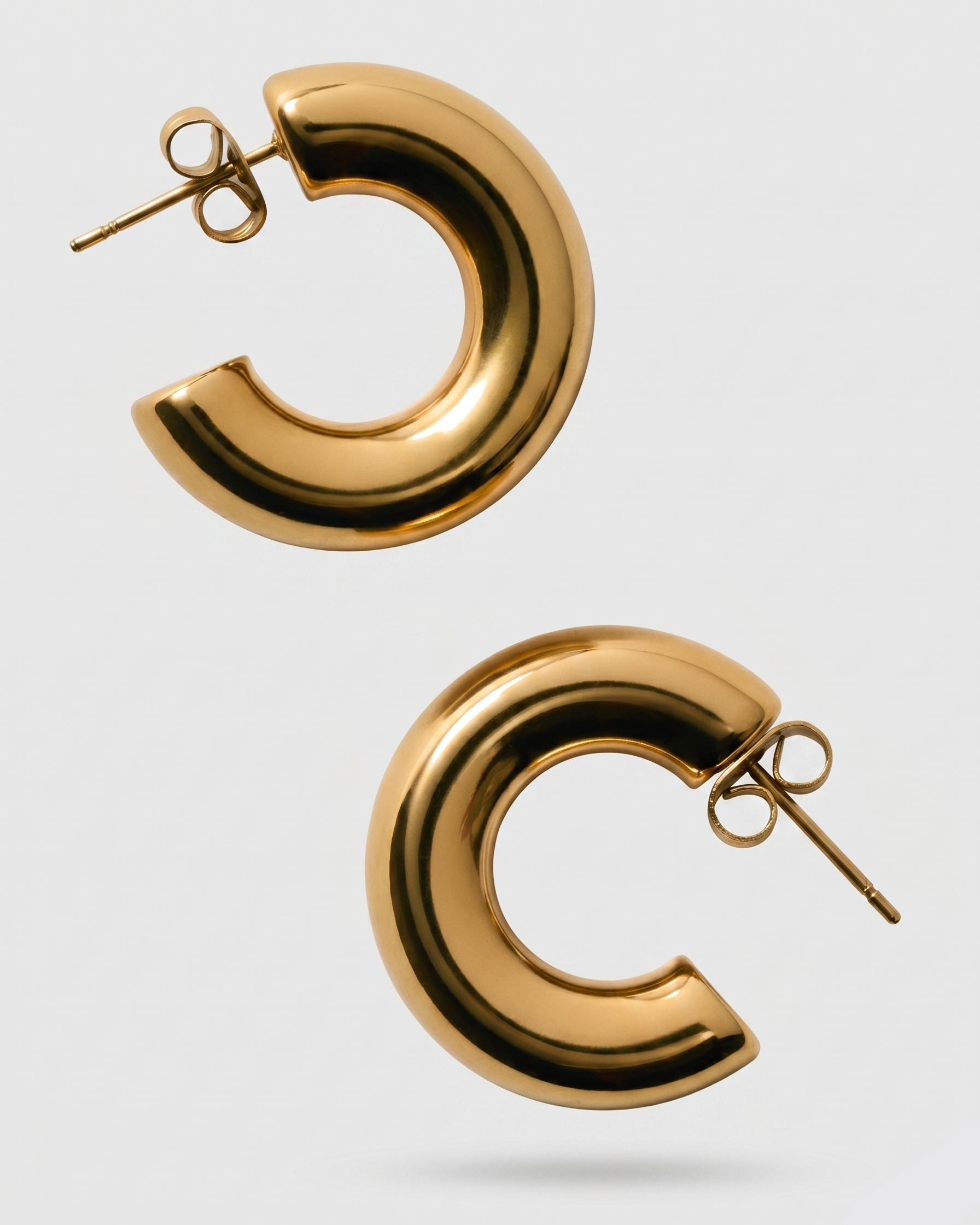 Gold hoop earrings on a light gray background