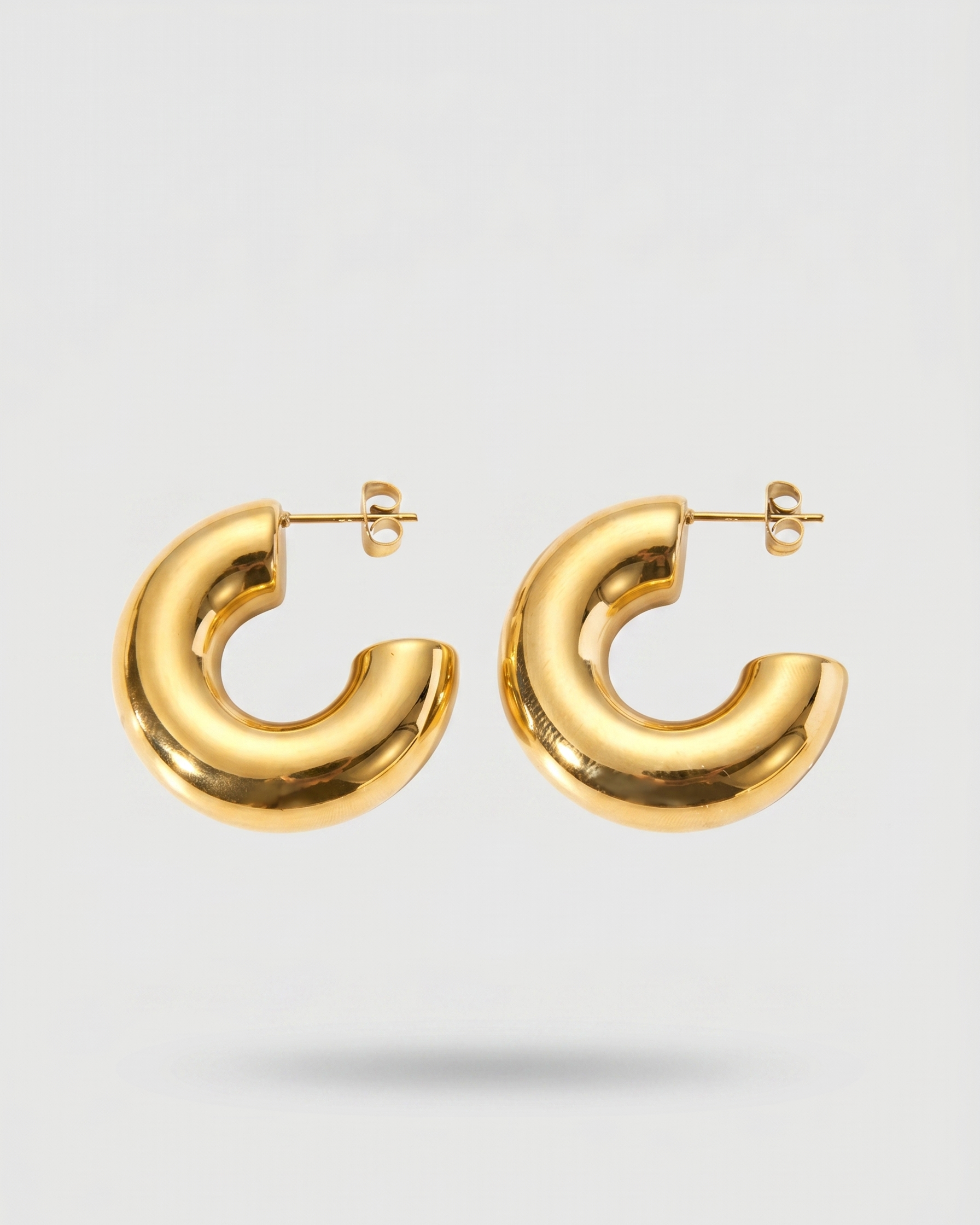 Gold hoop earrings on a light gray background