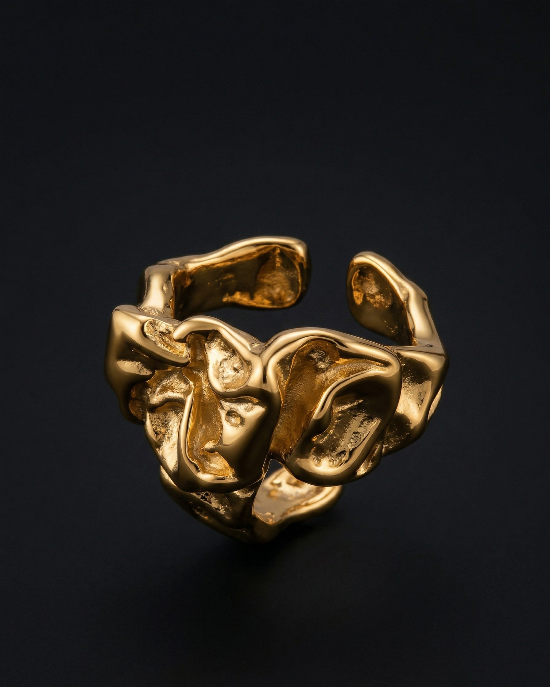 Gold ring with a textured design on a black background