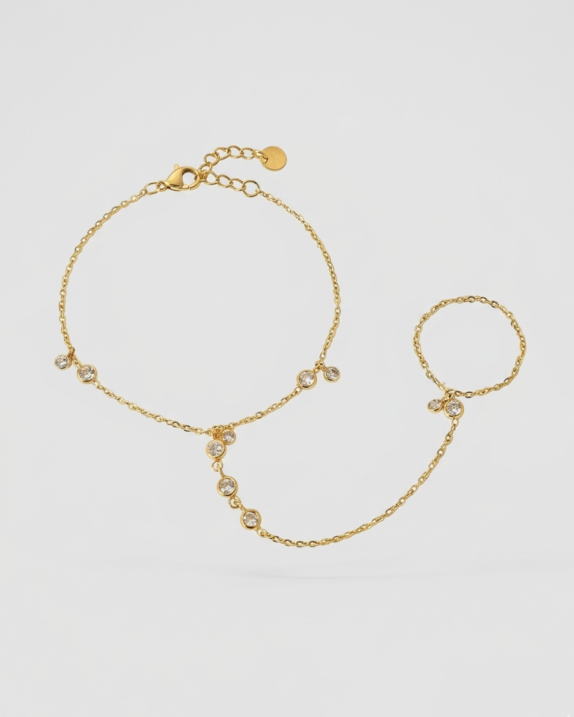 Gold bracelet with small beads on a light gray background