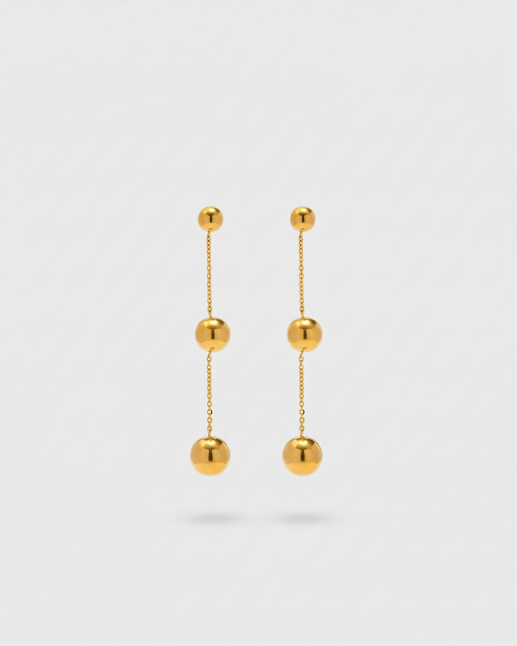 Pair of gold earrings on a light gray background