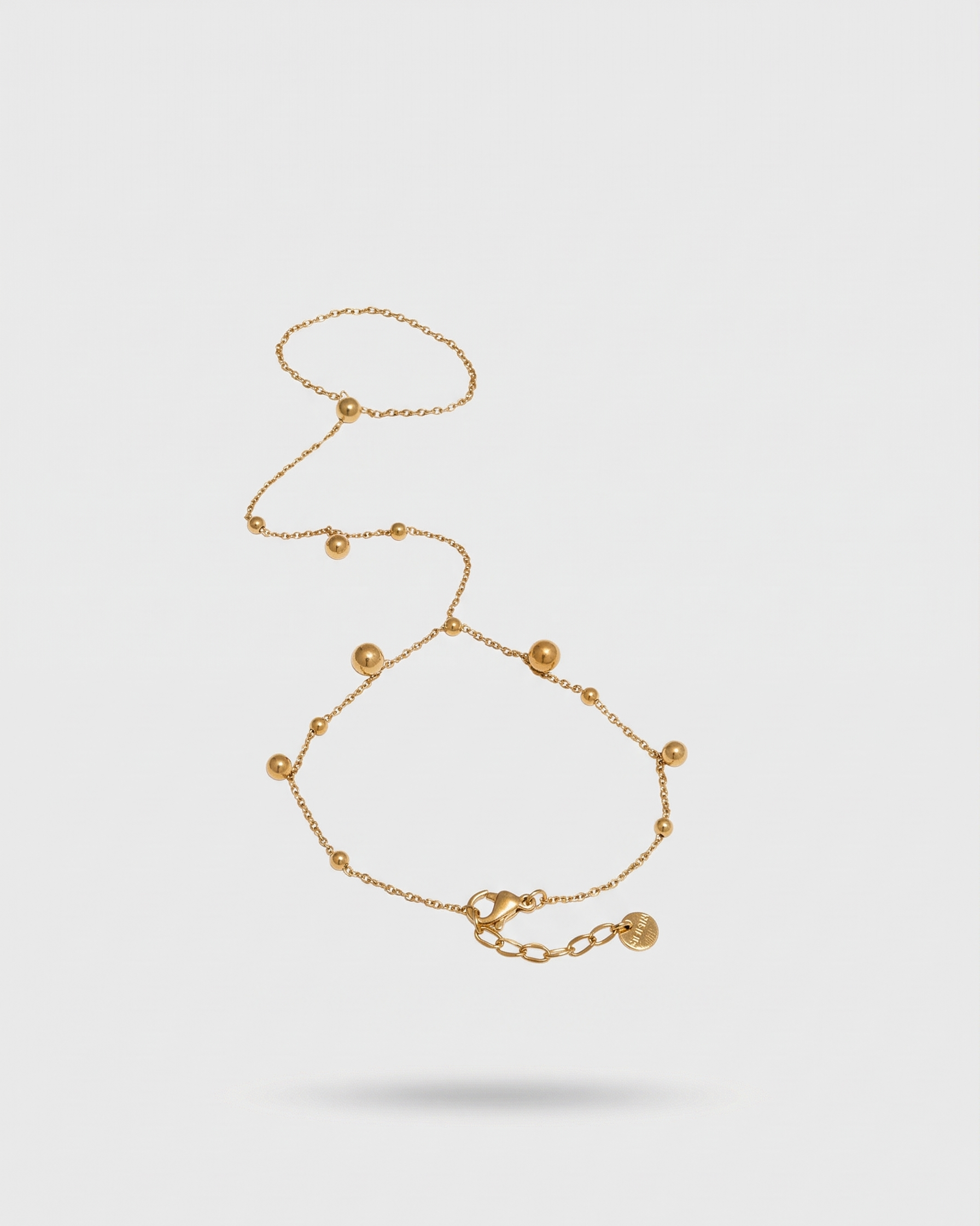 Gold bracelet on a light gray background