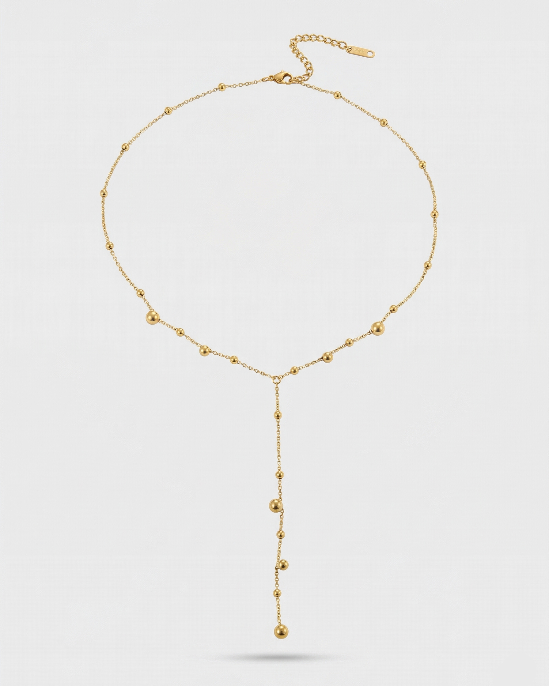 Gold necklace on a light gray background