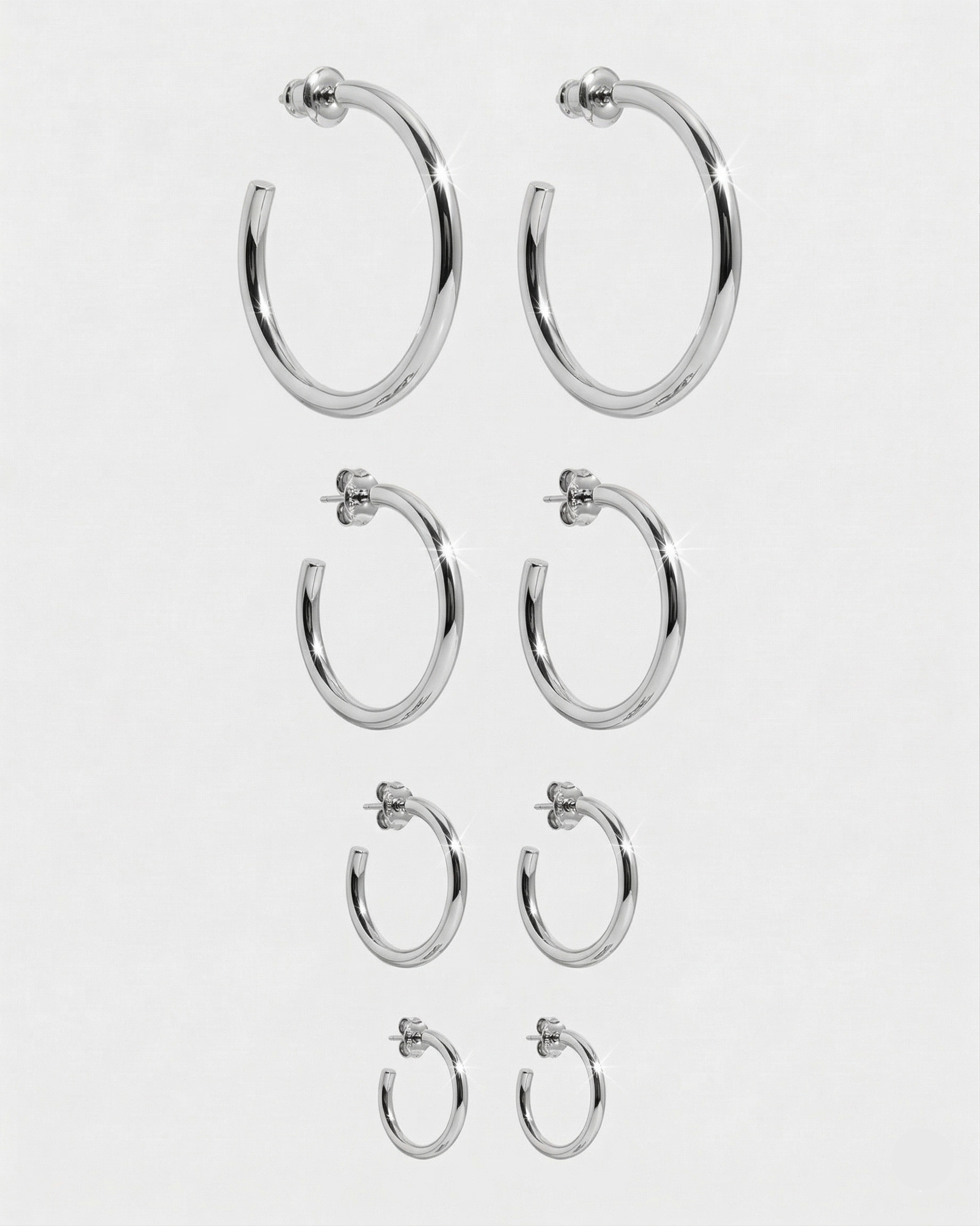 Set of silver hoop earrings on a white background