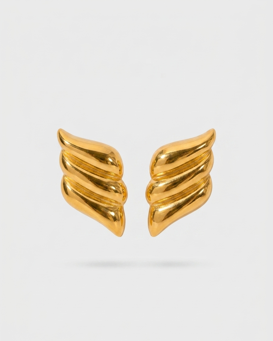 Pair of gold wing-shaped earrings on a light gray background