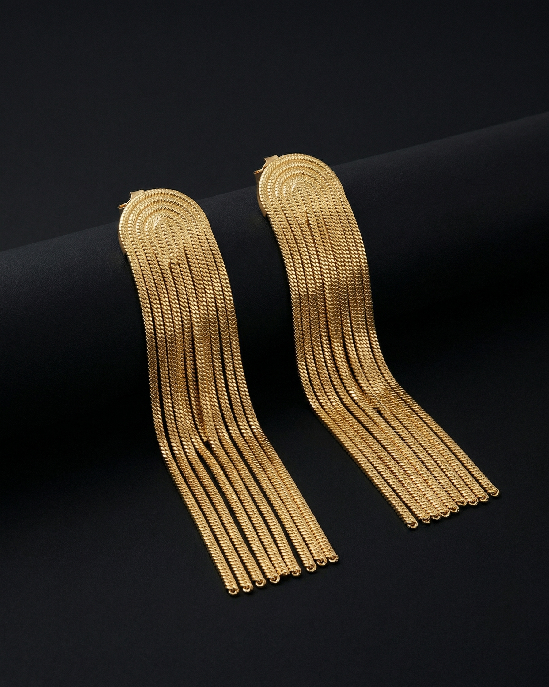 Two gold earrings  on a black background