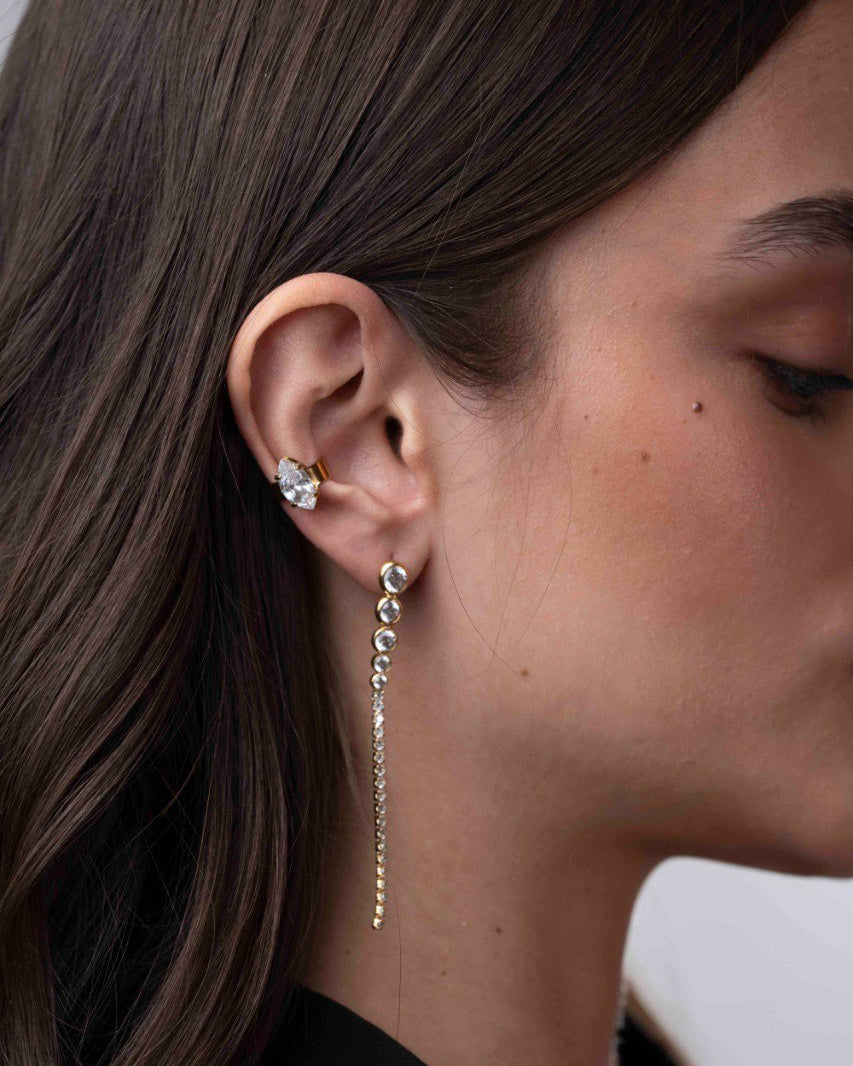 Close-up of a person wearing earrings with a neutral background