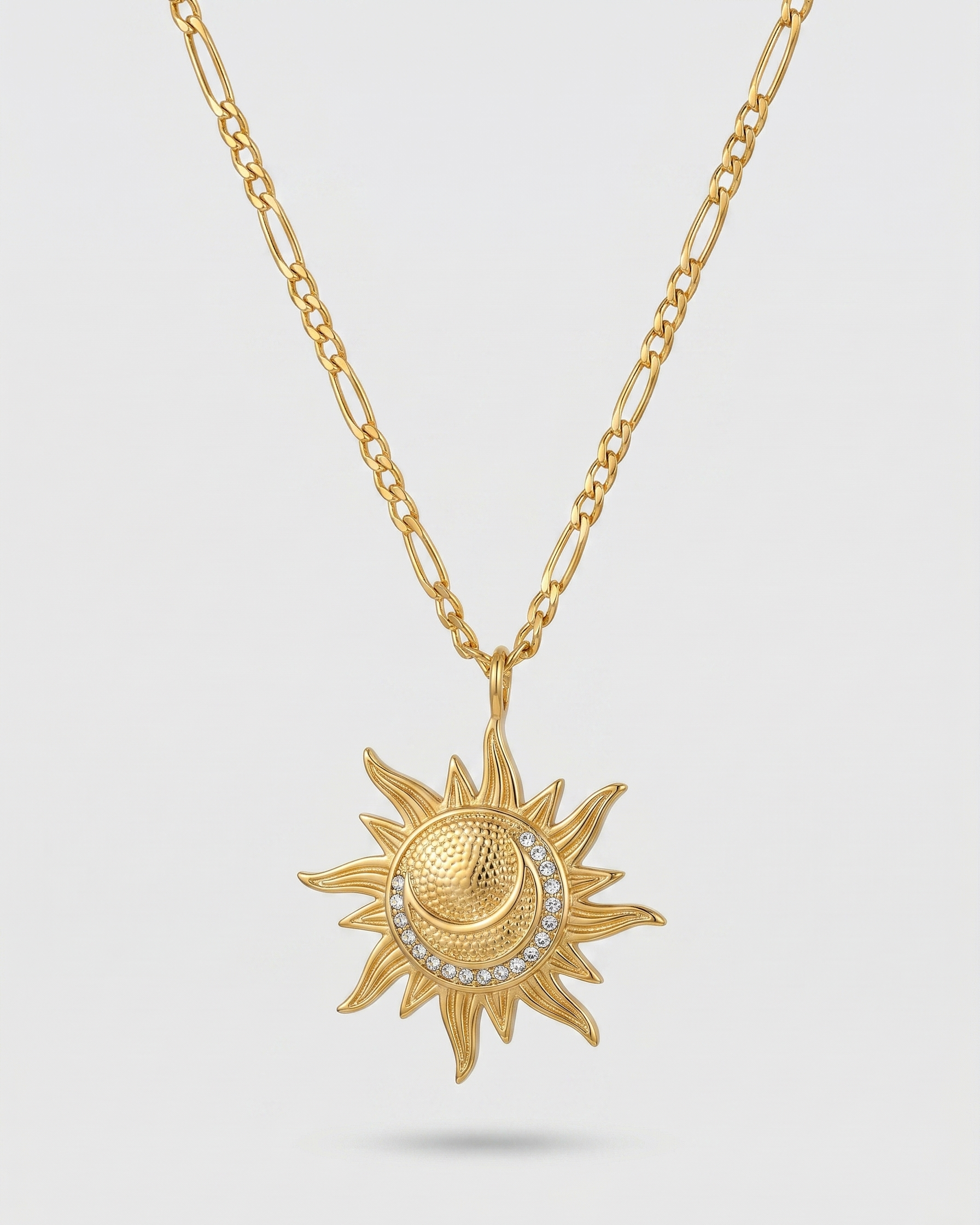 Gold sun-shaped pendant necklace on a light gray background