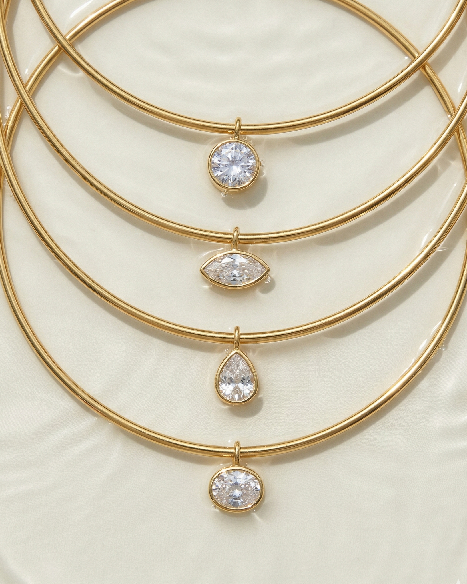 Set of gold necklaces with various cut gemstones on a light background