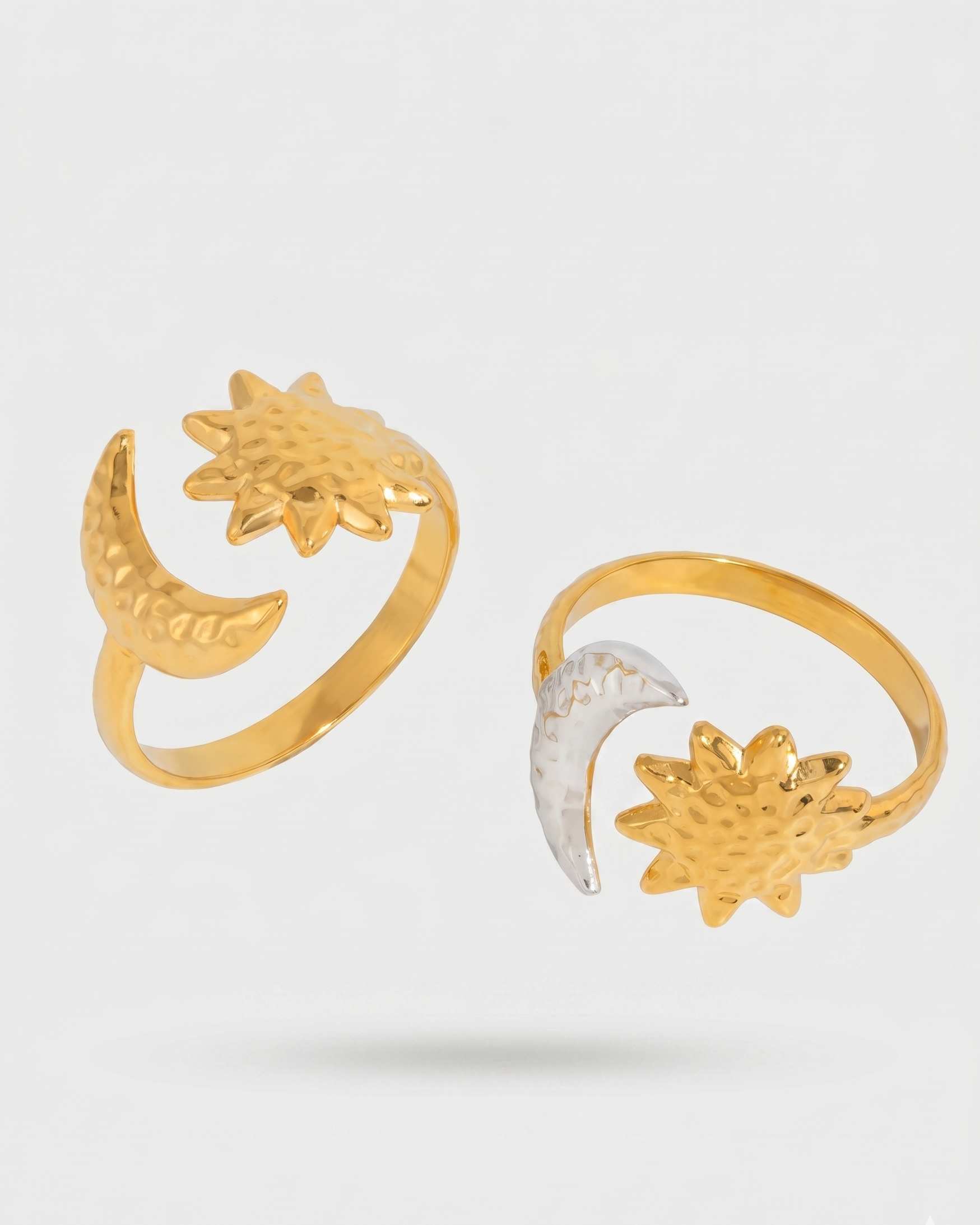 Two gold rings with sun and moon designs on a white background