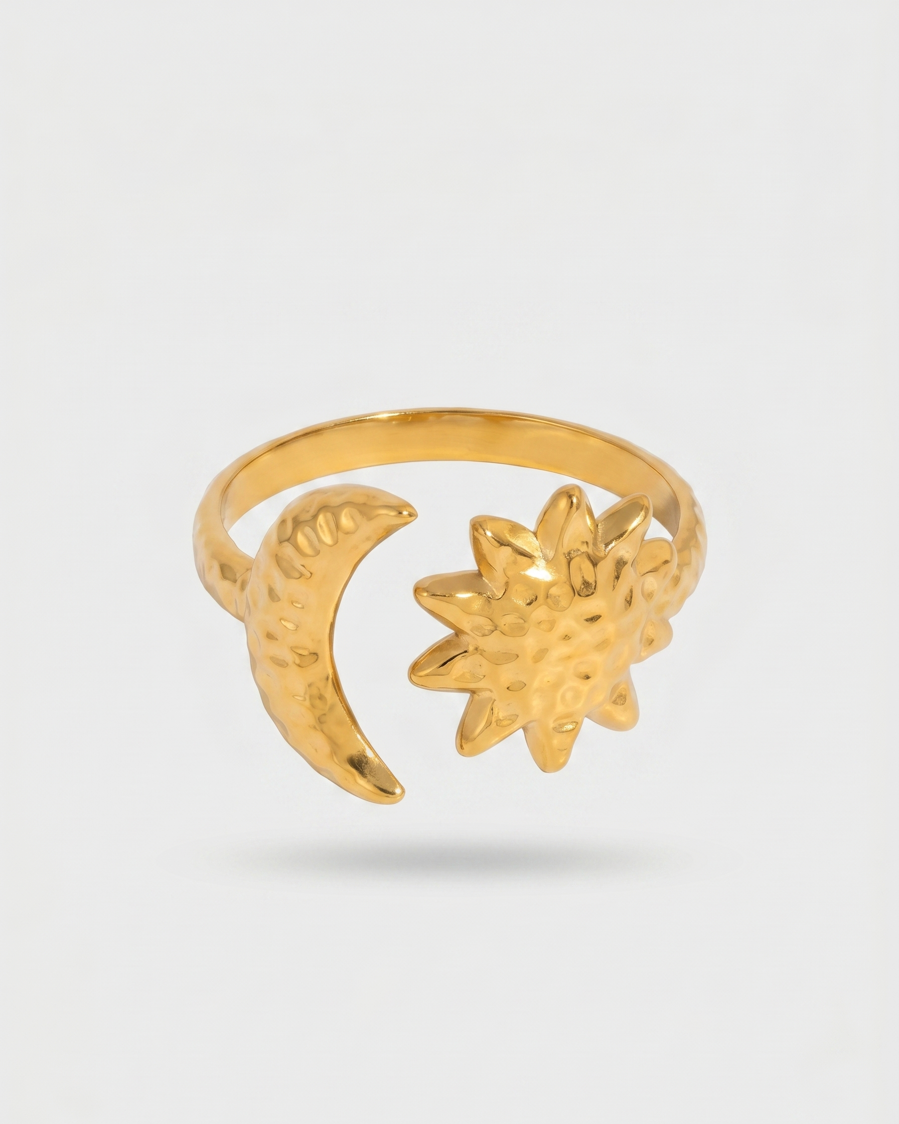 Gold ring with moon and star design on a white background