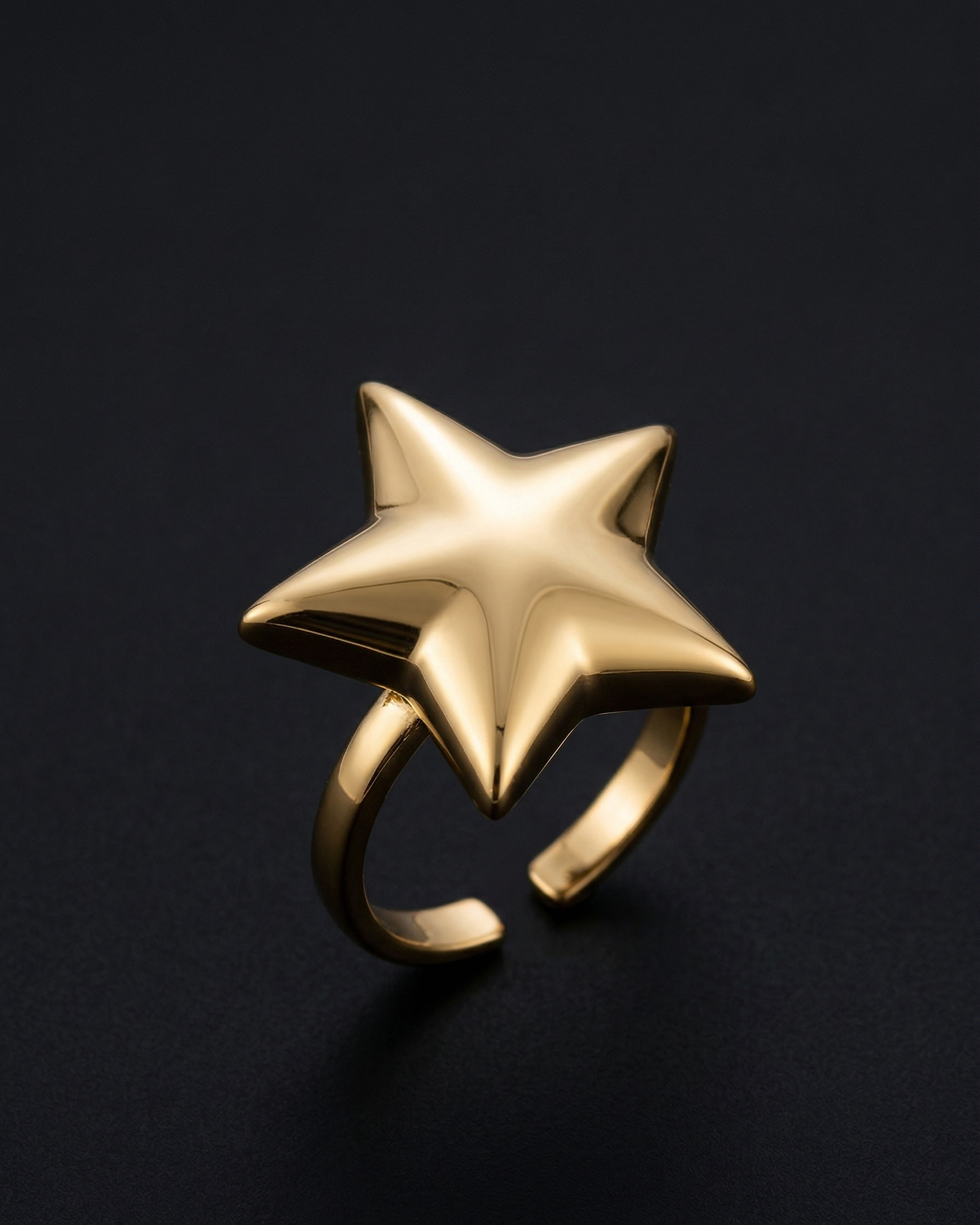Gold star-shaped ring on a black background