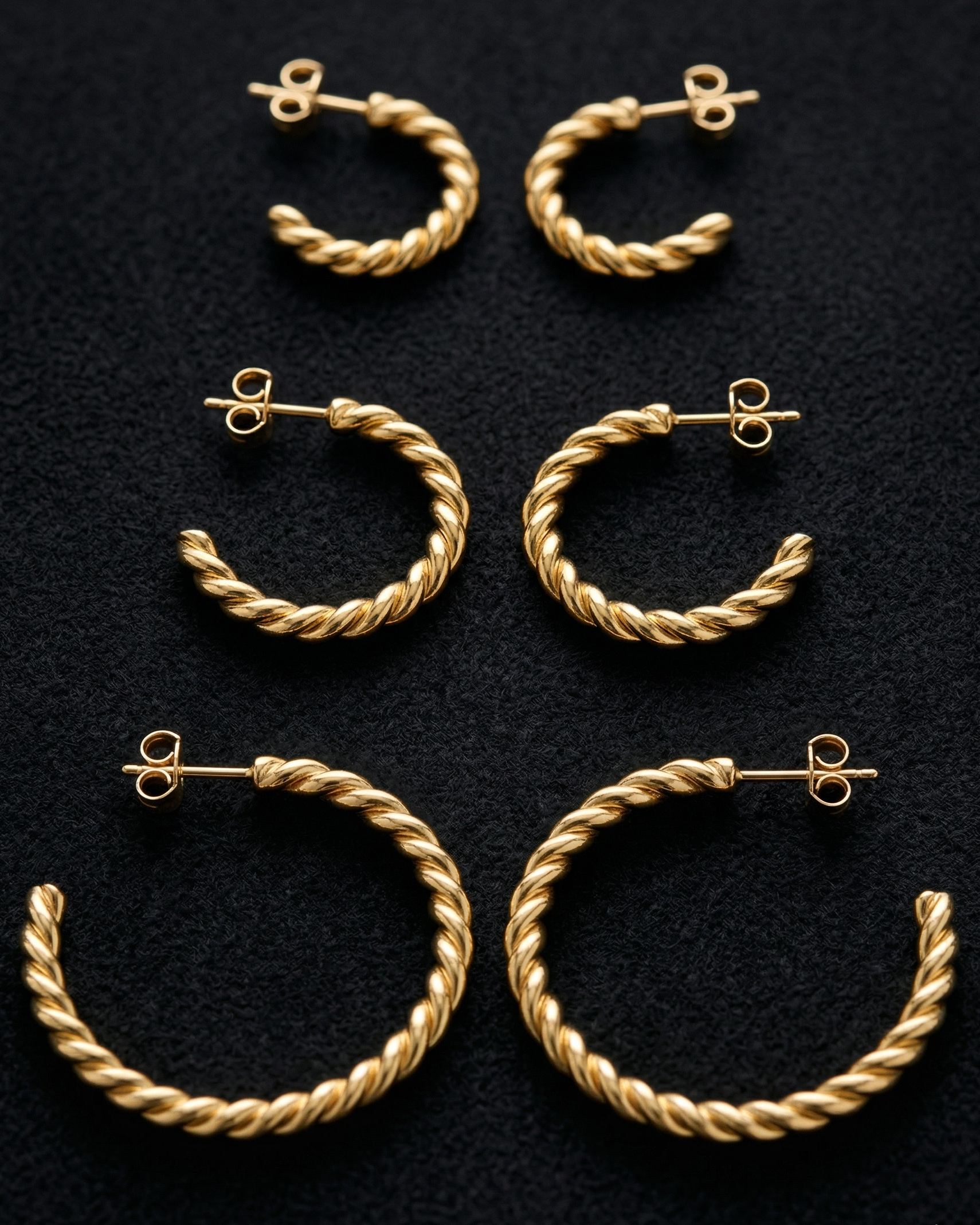 Set of gold hoop earrings on a black background